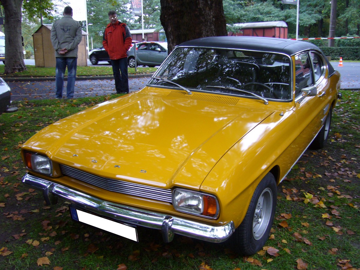 Ford Capri I. 1969 - 1973. Der Capri wurde im Januar 1969 vorgestellt. Bei seiner Einführung waren drei V4-motoren mit 1.3l, 1.5l und 1.7l und zwei V6-motoren mit 2.0l und 2.3l Hubraum lieferbar. Der abgelichtete Capri ist ein 1700 GT im Farbton maisgelb. Er stammt aus dem Jahr 1971 und ist mit dem 1699 cm³ großen V4-motor mit 75 PS motorisiert. Der 1700 GT kostete 1971 DM 8900,00. Besucherparkplatz der Historicar am 17.10.2015.