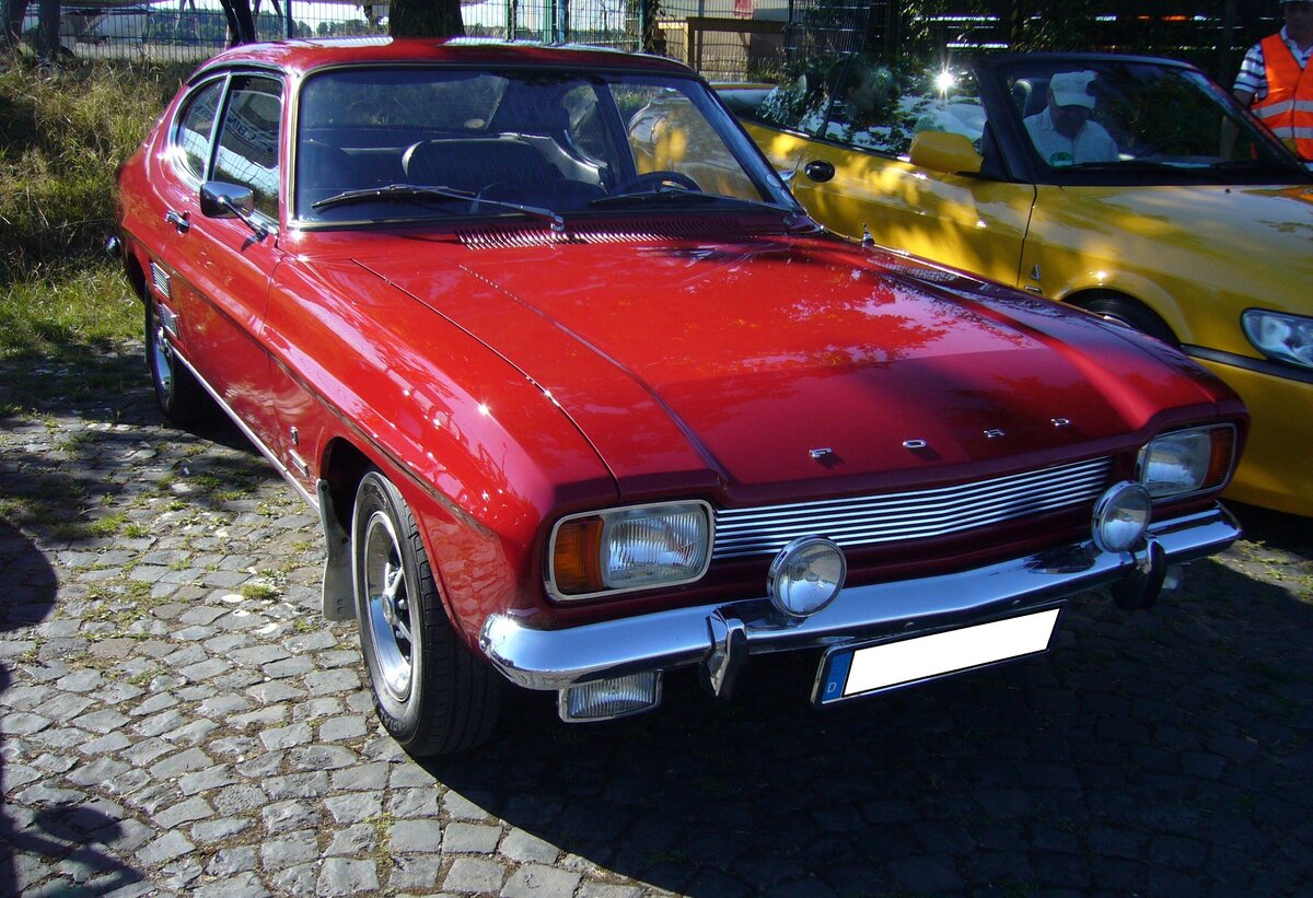 Ford Capri I, gebaut in den Jahren von 1969 bis 1973. Der Capri wurde im Januar 1969 vorgestellt. Er war eine Gemeinschaftsentwicklung von Ford Deutschland und Ford Great Britain. Bei seiner Markteinführung waren drei V4-Motoren mit 1.3l, 1.5l und 1.7l und zwei V6-motoren mit 2.0l und 2.3l Hubraum lieferbar. Der abgelichtete Capri ist ein 1700 GT im Farbton drachenrot. Er stammt aus dem Jahr 1970 und ist mit dem 1699 cm³ großen V4-motor mit 75 PS motorisiert. Der 1700 GT kostete im Jahr 1970 DM 8.900,00. Oldtimertreffen am Flughafen Essen/Mülheim am 07.08.2022.
