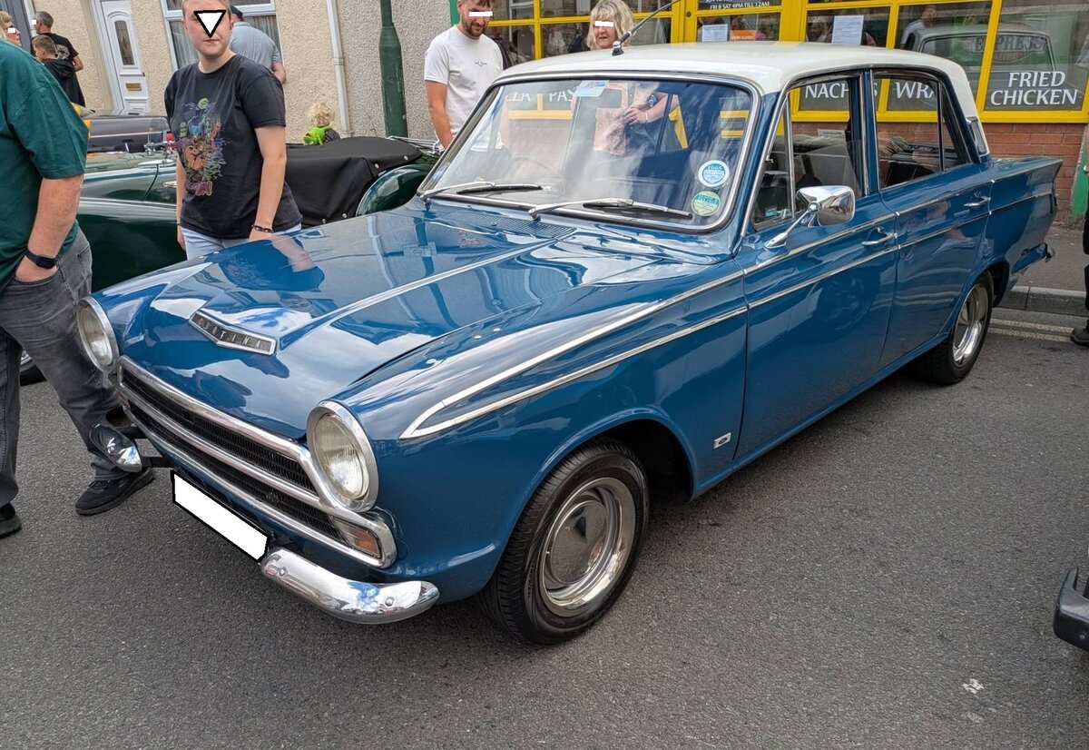 Ford Cortina MK1 1500 in der Karosserieversion viert�rige Limousine aus dem Jahr 1965. Gebaut wurde der Cortina MK1 1962 bis 1966 bei Ford/GB. Der Cortina war als zwei- und viert�rige Limousine und als f�nft�riges Kombimodell namens  Estate  lieferbar. Das Modell war das britische Gegenst�ck zum deutschen Ford Taunus P4. Au�erhalb Englands wurde das Modell recht erfolgreich in die BeNeLux-Staaten, in die Schweiz und nach �sterreich verkauft. Das Modell war wahlweise mit zwei Vierzylinderreihenmotor lieferbar: 1198 cm� mit 49 PS oder 1498 cm� mit 60 PS, wie der abgelichtete Cortina MK1. Brynmawr Classic Car Show/South Wales am 26.07.2026.