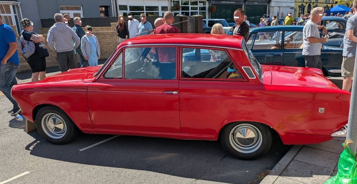 Ford Cortina MK1 GT aus dem Jahr 1965. Ford/GB stellte den Cortina 1962 vor, und schon bald wurde dieses Modell mit seiner charakteristischen rechteckigen Form zu einem der beliebtesten Auto-Modelle in Europa. Bereits im Fr�hjahr 1963 stand der Cortina GT bei den H�ndlern. Eine sportlichere Version des  normalen  Cortina. Er war somit eine perfekte Mischung aus Leistung und Eleganz. Die GT-Variante hatte, ein ab Werk, tiefergelegtes und straffer abgestimmtes Fahrwerk. Der Vierzylinderreihenmotor dieses  GT  im Farbton dragon red hat einen Hubraum von 1498 cm� und leistet 75,5 PS. Brynmawr Classic Car Show/South Wales am 26.07.2026.