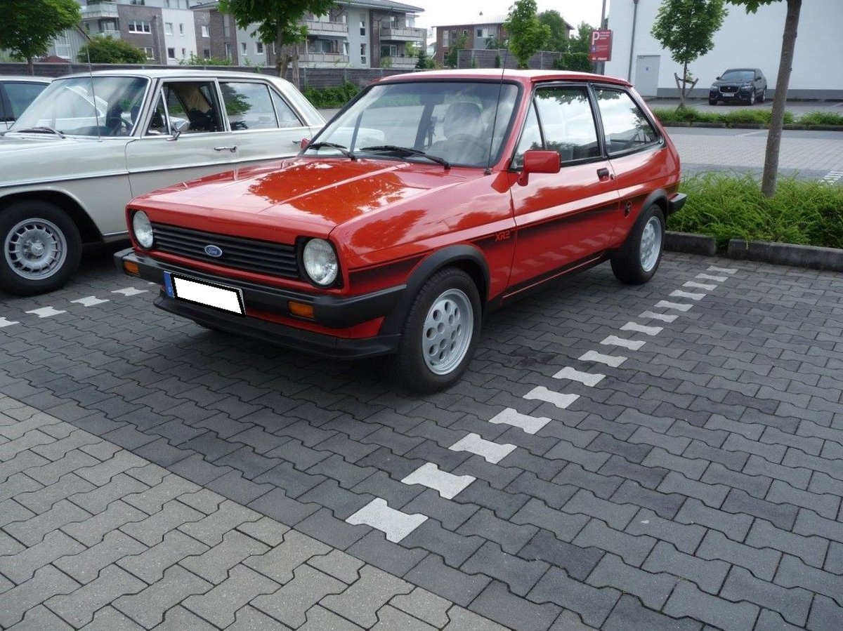 Ford Fiesta MK1 XR2, gebaut von 1981 bis 1983. Mit dem Fiesta begaben sich die Kölner 1976 zum ersten Mal auf den Markt für Kleinwagen. Anfangs gab es für den europäischen Markt nur Motorisierungen von 1.0l mit 40 PS bis 1.3l mit 66 PS. Für den Export in die USA wurde schon seit Modelleinführung im Werk Saarlouis ein Fiesta mit dem bekannten Kent-Motor gebaut. Im Jahr 1981 kam dieses Modell als Fiesta XR2 auch auf den deutschen Markt. Dieser, im Farbton sonnenrot lackierte XR2, wird von einem Vierzylinderreihenmotor angetrieben, der aus einem Hubraum von 1596 cm³ eine Leistung von 84 PS erbringt. Die Höchstgeschwindigkeit gab Ford mit 170 km/h an. Oldtimertreffen in Kamp-Lintfort im Herbst 2018.