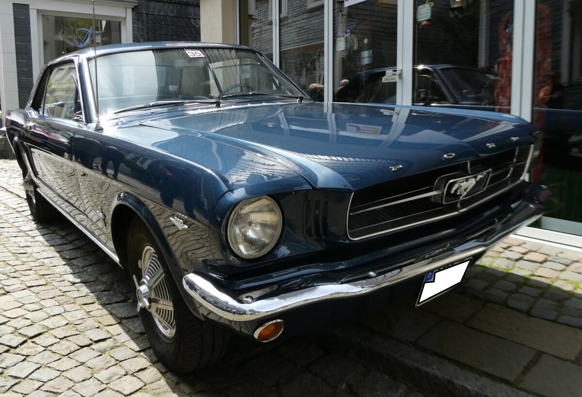 Ford Mustang 1 in der Karosserieversion Hardtop Coupe aus dem Jahr 1965. Der Wagen ist im Farbton caspian blue lackiert. Der gezeigte Mustang ist mit dem nicht so häufig georderten V8-Motor mit einem Hubraum von 260 cui (4261 cm³) und einer Leistung von 164 PS ausgerüstet. 15. Oldtimertreffen des AMC Essen-Kettwig am 01.05.2023. 