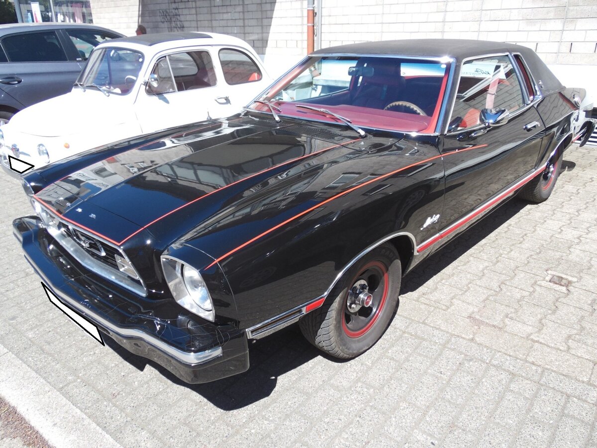 Ford Mustang II Stufenheck-Coupe der Modelljahre von 1973 bis 1978. Hier wurde ein 1976´er Mustang II im Farbton M1724 = black abgelichtet. Unter der Motorhaube verrichtet ein V6-Motor seinen Dienst, der aus einem Hubraum von 2799 cm³ 97 PS leistet. 18. Kettwiger Oldtimerfrühling in Essen Kettwig am 01.05.2026.