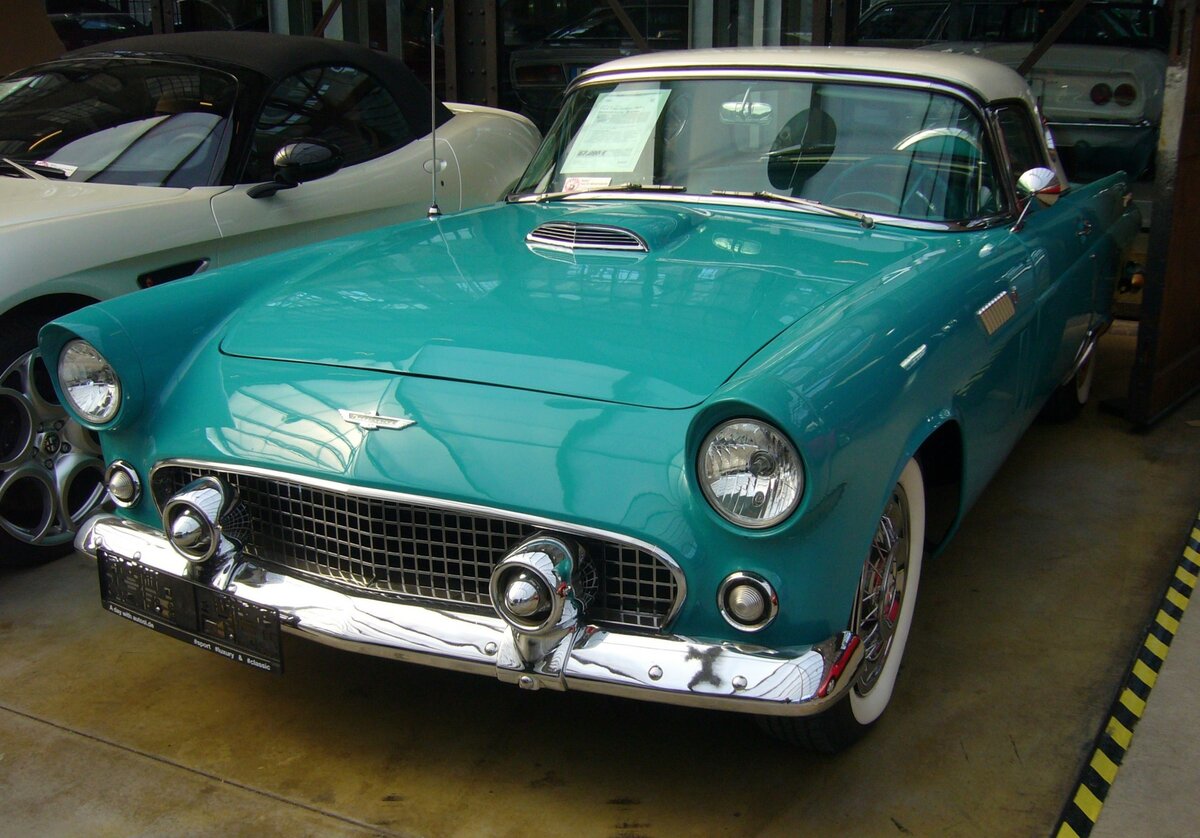 Ford Thunderbird des Modelljahres 1956 im Farbton peacock blue. Anfang der 1950`er Jahre schwappte die Sportwagenwelle aus Europa auch in die USA. Im Jahr 1953 reagierte Chevrolet mit der Corvette auf diesen Trend. 1955 kam dann aus Dearborn die Antwort in Form des Thunderbird. Das Modell war so erfolgreich, das im Jahr 1956 20 mal mehr Thunderbird`s als Corvette`s verkauft wurden. Der V8-Motor hat einen Hubraum von 4785 cm³ und leistet 212 PS. Classic Remise Düsseldorf am 19.04.2023.  
