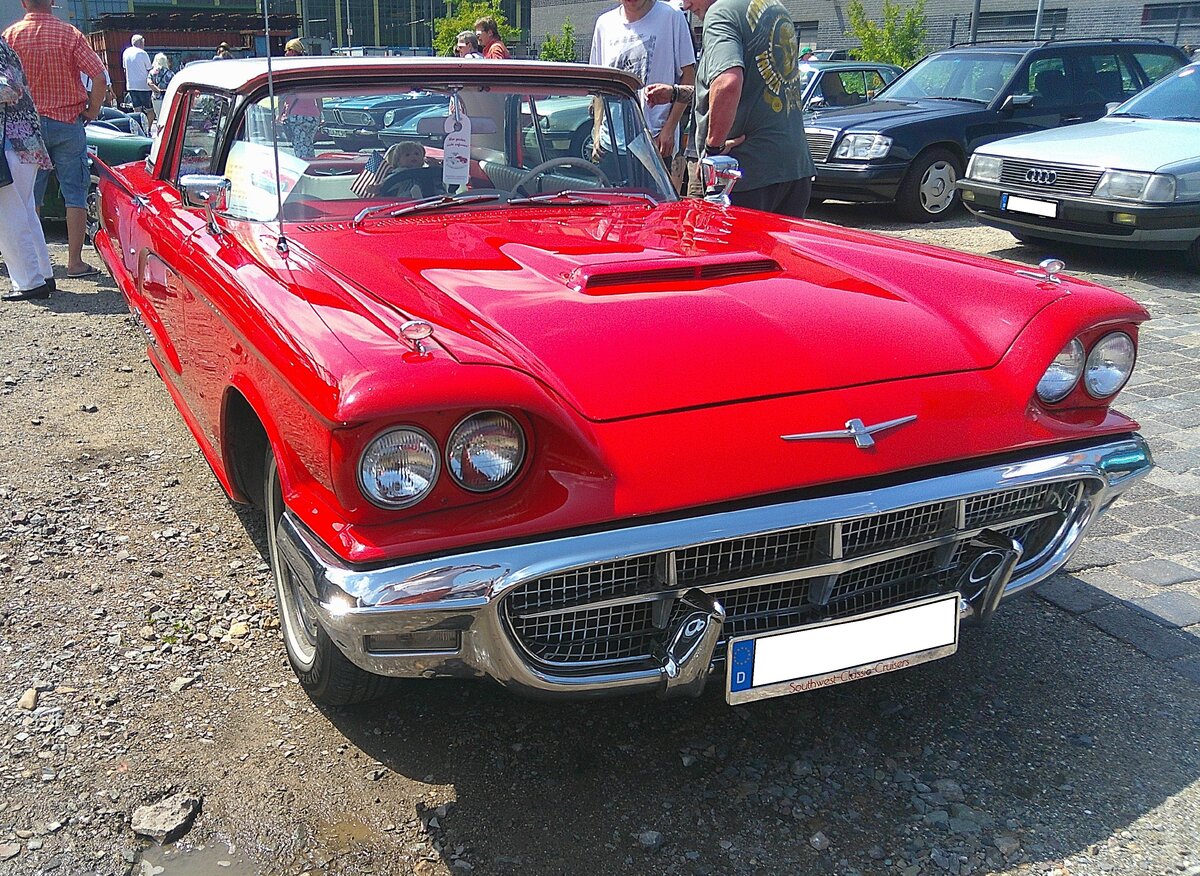 Ford Thunderbird Hardtop Coupe im Farbton monte carlo red aus dem Jahr 1960. Er stammt also aus dem letzten Modelljahr der so genannten  Square birds , die 1958 auf den Markt kamen. Von der Optik sind sich alle drei Jahrg�nge sehr �hnlich. Nur das 1960´er-Modell hat allerdings auf jeder Fahrzeugseite drei Heckleuchten. Von diesem Coupe-Modell setzte Ford im Jahr 1960 80.938 Einheiten, zu einem Preis ab US$ 3755,00 ab. Vom Cabriolet-Modell waren es dann noch einmal 11.860 Autos ab US$ 4222,00. Als Motorisierung dient diesem  Donnervogel  der damals neue V8-Motor mit einem Hubraum von 352 cui (5766 cm�) mit einer Leistung von 300 PS. 18. Oldtimerfestival an der  Alten Dreherei  in M�lheim an der Ruhr am 21.06.2026.