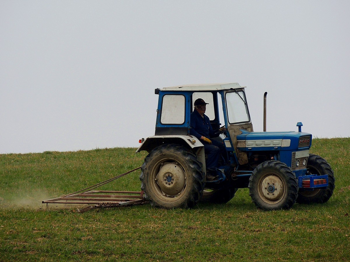 FORD-Traktor verrichtet Arbeiten mit einer Wiesenegge; 150321