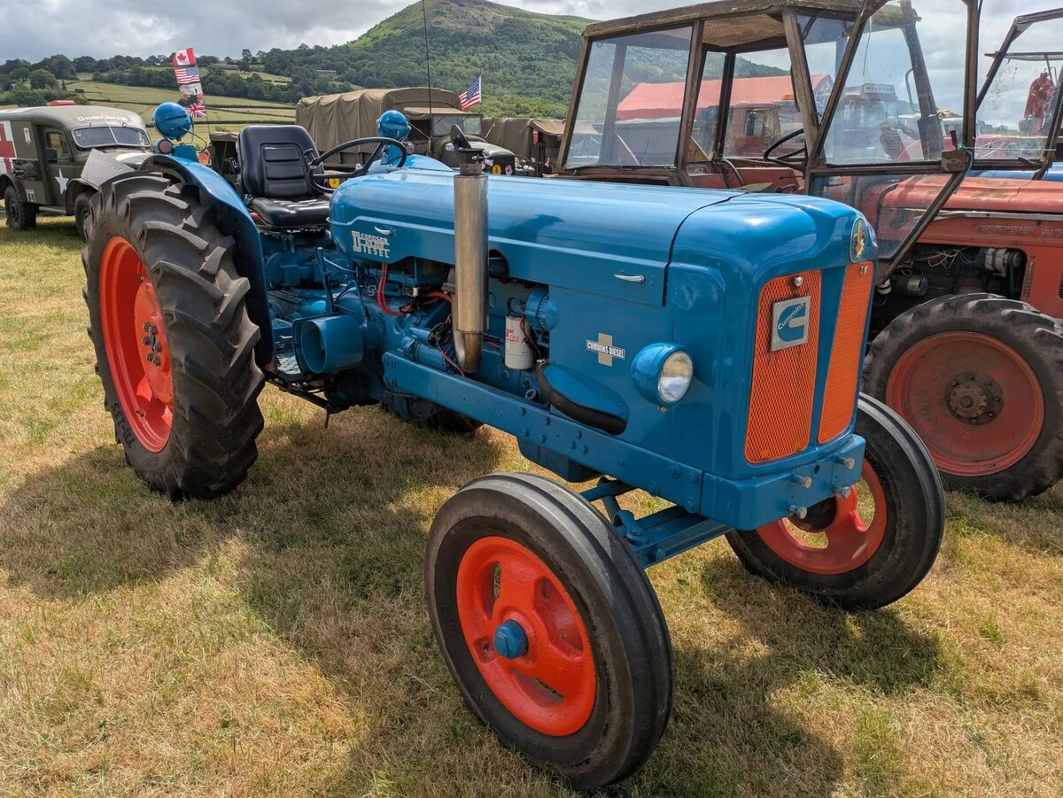 Fordson Diesel Major aus dem Jahr 1955. Allerdings wurde dieser Ackerschlepper etwas  aufgepimpt . Wie man erkennen kann, sind die Fahrgestelltr�ger, gegen�ber einem serienm��igen Modell dieses Baujahres verl�ngert worden. Dem entsprechend wurde dann nat�rlich die Motorhaube mit zus�tzlichen Blechen verl�ngert. Motorentechnisch wurde dieser Fordson dann auf den legend�ren Cummins 5.9 Litre Dieselmotor der so genannten B-Serie, umger�stet. Dieser Sechszylinderreihendieselmotor hat einen Hubraum von 5883 cm� und leistet mindestens 160 PS. Durch technische Verfeinerungen, wie z.B. Kompressoren oder �hnliches sind sogar Motorleistungen von bis zu 325 PS machbar. Classic car meeting in Pontypool/South Wales am 17.05.2025.