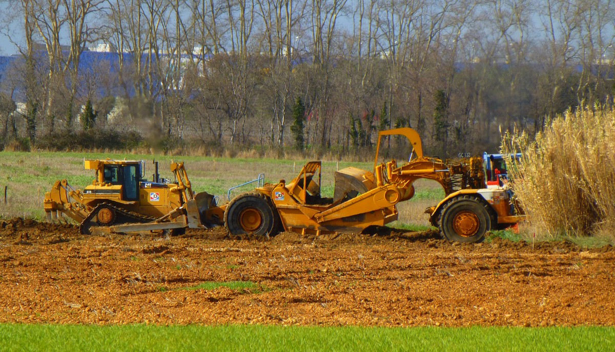 Frankreich, Languedoc, Hérault, Montpellier-Agglomération. Die neue Hochgeschwindigkeitsstrecke der SNCF zur Umgehung von Nîmes und Montpellier verläuft bei Montpellier parallel zur neuen Autobahn A9 um Montpellier. Siehe Karte wo sowohl die neue Autobahn, wie die neue Hochgeschwindigkeitsstrecke der SNCF eingezeichnet sind. Eine Planierraupe Cat D7 hilft dem Schürfzug Caterpillar 631E weiter. 24.02.2014
