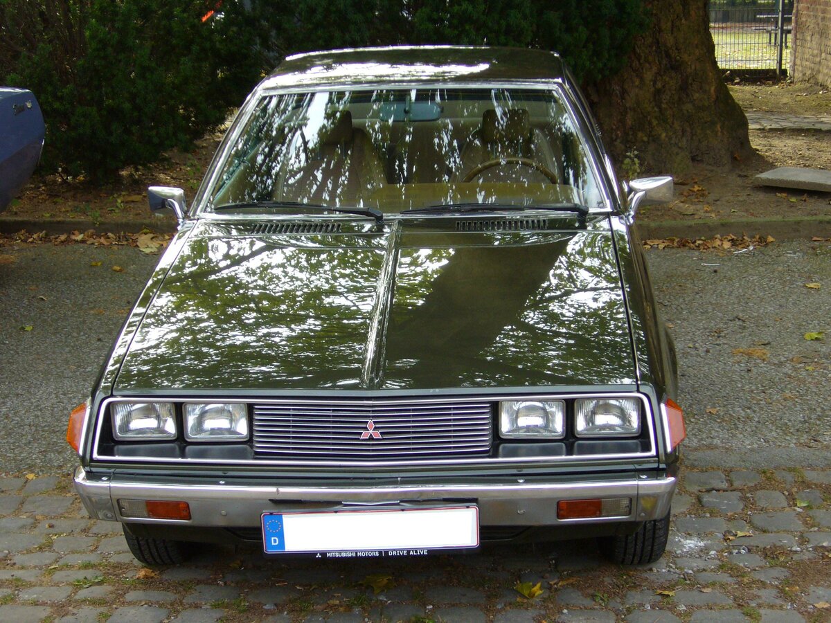 Frontansicht eines Mitsubishi Sapporo der Baureihe A121 bzw. A123, wie er von 1975 bis 1980 im kleinsten Mitsubishi-Werk Okazaki gebaut wurde. Das Modell basierte auf dem Fahrgestell der Limousine Galant. Die spitze Bugpartie mit den rechteckigen Doppelscheinwerfern und die gewölbte Panorama-Heckscheibe sorgten dafür, dass er in der Masse der damals stark verbreiteten VW Scirocco, Ford Capri und Opel Manta auffiel. Das Modell war mit zwei Vierzylinderreihenmotoren lieferbar: 1597 cm³ mit 75 PS (A121) oder 1995 cm³ (A123) mit 90 PS, 98 PS oder 108 PS. Insbesondere der 1.6l Motor hatte mit dem recht schweren Viersitzer seine liebe Mühe. Nippon Classic Days an der Essener Dampfbierbrauerei im September 2022.