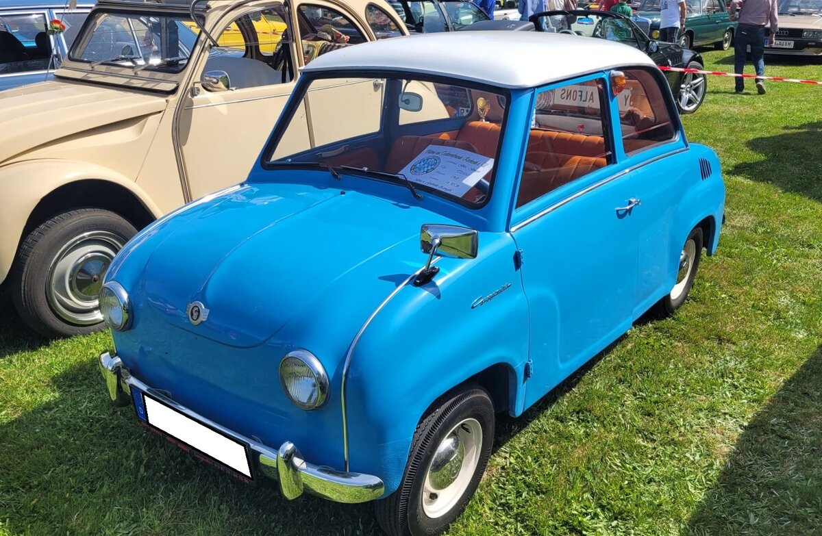 Glas Goggomobil T250 Limousine, gebaut von 1955 bis 1969 in Dingolfing. Vorgestellt wurde die winzige Limousine im Herbst 1954. Im Februar 1955 begann bei der Hans Glas GmbH die Serienfertigung. Der Wagen war auch als T300 und ab 1957 sogar als T400 lieferbar. Mehr als 75% der Fahrzeuge wurden allerdings mit dem 250 cm� Motor ausgeliefert. Diese Tatsache war den vielen Inhabern des  alten  F�hrerscheines der Klasse IV geschuldet. Hier handelt es sich um eine Limousine im Farbton azurblau, die nach 1964 produziert wurde. Dieses ist an den vorn angeschlagenen T�ren zu erkennen. Der im Heck verbaute, Gebl�se-gek�hlte, Zweizylinderzweitaktmotor hat beim 250´er-Modell einen Hubraum von 247 cm� und leistet 13,6 PS. Oldtimertreffen Altenthann/Oberpfalz am 03.05.2026.