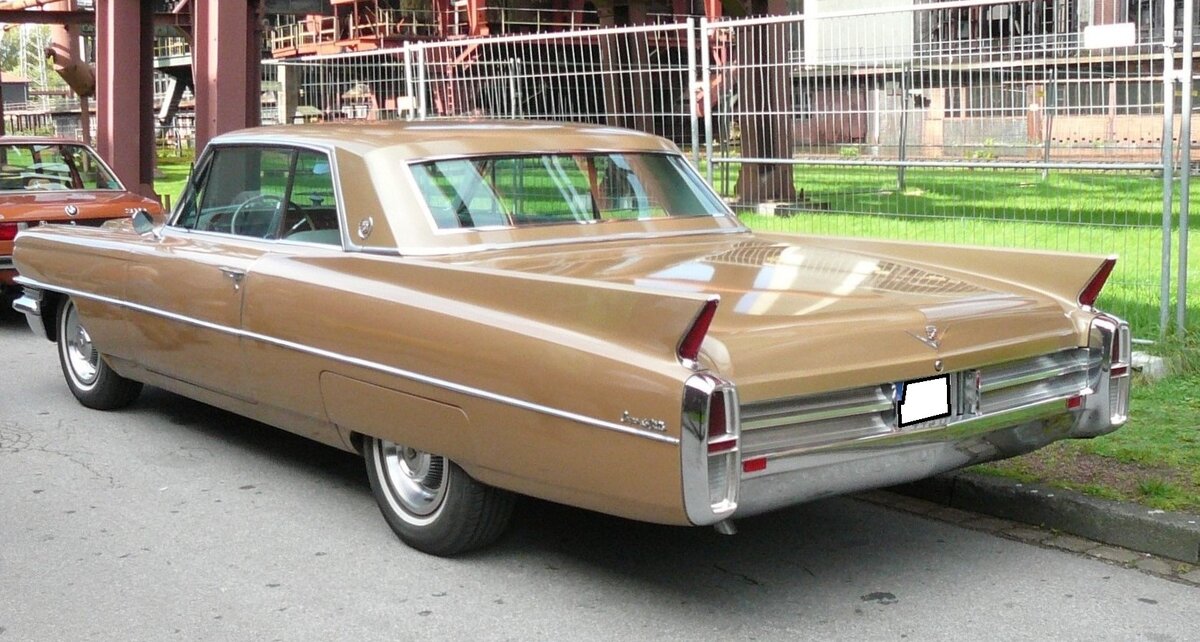 Heckansicht eines Cadillac Coupe de Ville aus dem Jahr 1964 im Farbton sierra gold. Aufnahme erfolgte auf dem ehemaligen Oldtimertreff Kokerei Zollverein in Essen.
