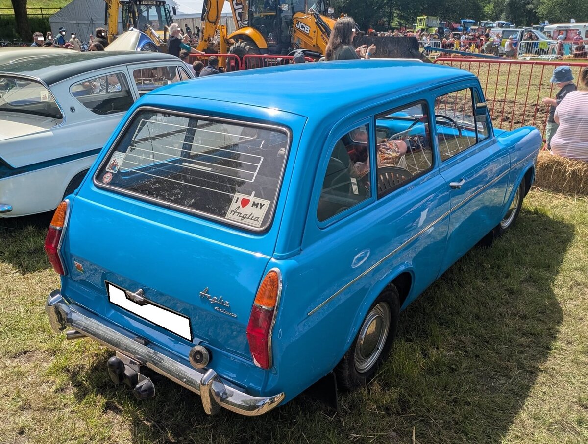 Heckansicht eines Ford Anglia 105E  Estate  aus dem Jahr 1966. W�hrend die eigenwillig gestylte Anglia 105E-Limousine bereits 1959 auf den Markt kam, brachte Ford/GB im September 1961 das dreit�rige Kombimodell  Estate  auf den Markt. Vorher hatten sich schon zwei externe Karosseriebaufirmen an Kombimodellen dieses Typs versucht. Der Estate wurde von all den Kunden bestellt, die etwas mehr Gep�ck transportieren wollten bzw. mussten. Die R�cksitzbank lie� sich nach vorne klappen und die Sitzfl�che flach umlegen. Dadurch entstand ein gro�er, ebener, Laderaum. Der vordere Teil des Fahrzeugs bis zur B-S�ule, war identisch mit dem der Limousine. Dahinter schloss sich nahtlos die relativ elegante Kombikarosserie an. Genau wie die Limousine war auch der  Estate  in den Ausstattungsvarianten  Standard“ und  Deluxe“ angeboten. Der Kombi verf�gte zudem �ber ein verst�rktes Fahrwerk und gr��ere Reifen, um das zus�tzliche Gewicht, das im Kofferraum transportiert werden konnte, besser zu bew�ltigen. Die Motorisierungen waren kongruent mit der der Limousine. Abergavenny Steam and Vintage Show am 27.05.2023.