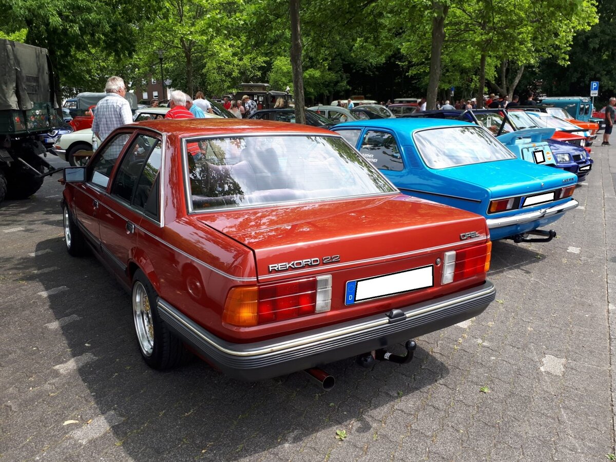 Heckansicht einer Opel Rekord E2 Limousine, wie sie von 1982 bis 1986 gebaut wurde. Der Rekord E stand ab August bei den Opel-Händlern. Er war als zwei- und viertürige Limousine und als drei- und fünftüriges Kombimodell namens CarAvan lieferbar. Ab Oktober 1982 kam der Rekord E2 auf den Markt. Äußerlich erkennbar an größeren Heckleuchten und einer  facegelifteten  Fahrzeugfront. Weitere Änderung war, dass die Limousine nur noch viertürig lieferbar war. Der hier abgelichtete Rekord E2 ist mit dem stärksten, damals lieferbaren Benzinmotor ausgerüstet. Dieser Vierzylinderreihenmotor hat einen Hubraum von 2197 cm³ und leistet 115 PS. Die Höchstgeschwindigkeit gaben die Rüsselsheimer mit 187 km/h an. Oldtimertreffen in Siegen am 19.06.2022.