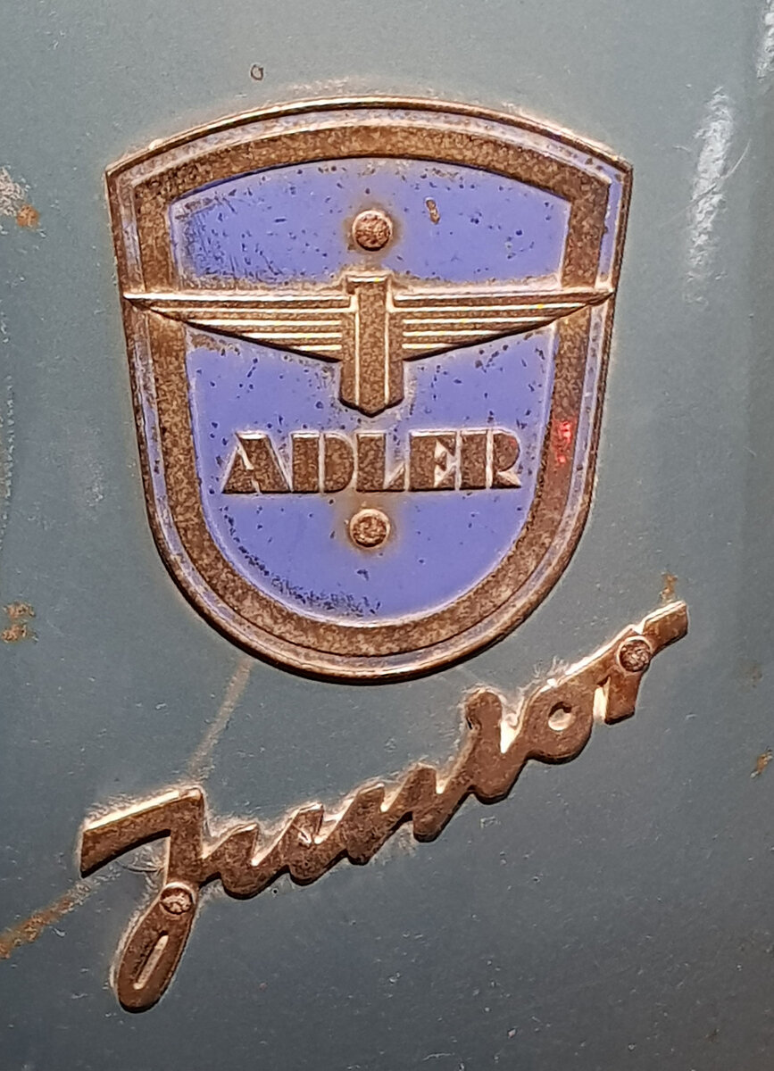 =Hersteller- und Typenembleme des Adler Junior-Motorroller, gesehen im Zylinderhaus in Bernkastel-Kues, 04-2023