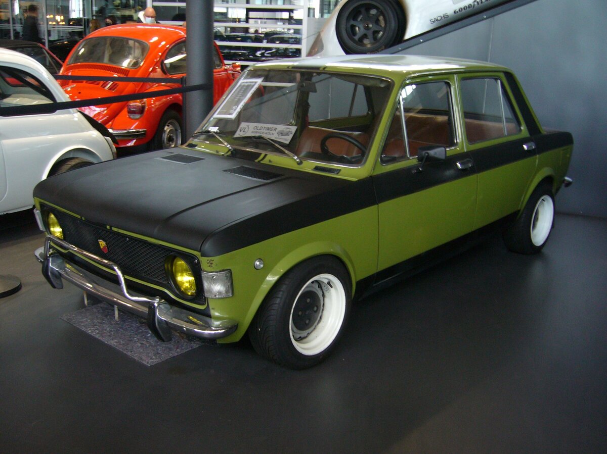 Hinter der Modellbezeichnung 128 verbirgt sich eine umfangreiche Typenreihe mit Karosserien als zwei- oder viertürige Limousine, Kombiwagen und Coupe. Das im Jahr 1969 vorgestellte Modell war von Anfang an mit zwei Vierzylinderreihenmotoren mit 1.1l und 1.3l Hubraum lieferbar. Des weiteren war es der erste Fiat mit Frontantrieb. Die abgelichtete Limousine ist ein Modell der ersten Serie, wie es von 1969 bis 1974 von den Bändern lief. In gezeigten Auto ist der kleinere Motor mit einem Hubraum von 1116 cm³ verbaut. Allerdings erreicht der Motor durch zeitgemäßes Tuning, damals sagte man  frisieren , eine Leistung von 95 PS. Motorworld Cologne am 19.02.2022.