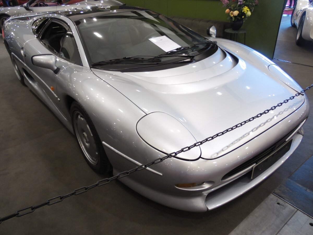 Jaguar XJ220. Der im Oktober 1988 auf der Automobilausstellung in Birmingham gezeigte Prototyp wurde von der Presse und dem Publikum begeistert aufgenommen. Die Auslieferung der 350 produzierten Fahrzeuge erfolgte von 1992 bis 1994. Die Ausstattung des Sportwagens war spartanisch. Es gab kein ABS, keine Servolenkung und noch nicht einmal eine Servo unterstützte Bremsanlage. Der Antrieb erfolgt durch einen V6-Motor mit doppelter Turboaufladung. Dieser  Sechsender  hat einen Hubraum von 3498 cm³ und leistet 549 PS. Die Höchstgeschwindigkeit gab die Marke aus Coventry mit 349 km/h an. Techno Classica Essen am 12.04.2025.
