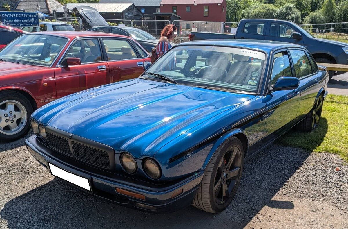 Jaguar XJR der Modelljahr 1997 bis 2003. Die XJR-Modelle waren die vom Werk technisch optimierten Limousinen der ohnehin schon gut motorisierten Luxuslimousine XJ. Das hier gezeigte Auto ist schon mit dem seit 1997 verbauten V8-Motor ausger�stet. Dieser hat einen Hubraum von 3996 cm� und erreicht mittels einer Kompressor-Aufladung zwischen 363 PS und 370 PS. Der gezeigte XJR d�rfte im Farbton antigua blue lackiert sein. Breakfast Classic meeting in Pontneddfechan/South Wales am 30.05.2026.