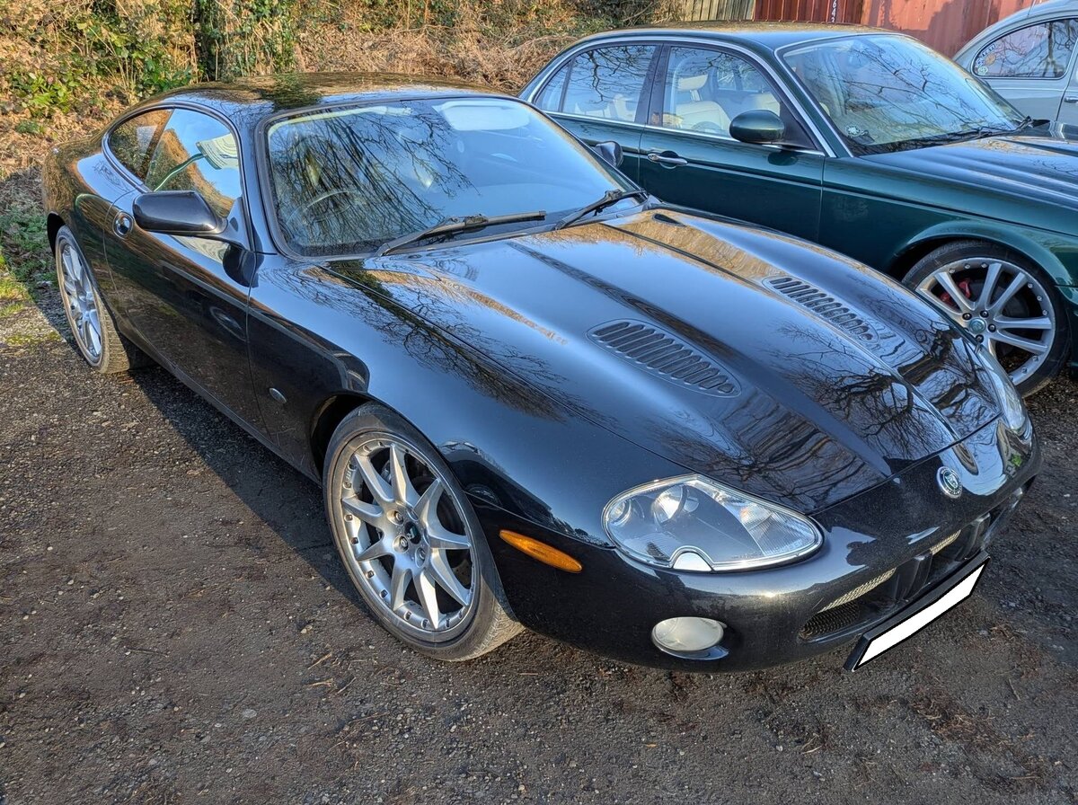 Jaguar XKR, wie er ab dem Spätsommer 2002 als Coupe (Foto) oder Cabriolet gebaut wurde. Serienmäßig war das Modell mit einem V8-Motor ausgerüstet, der aus einem Hubraum von 4196 cm³ 298 PS leistet. Wem diese Motorleistung nicht reichte, konnte alternativ das Modell mit Kompressor-Aufladung bestellen. Dann stieg die Motorleistung auf 396 PS. September 2024 auf dem Besucherparkplatz eines Pubs in Pont-Neddfechan/South Wales.