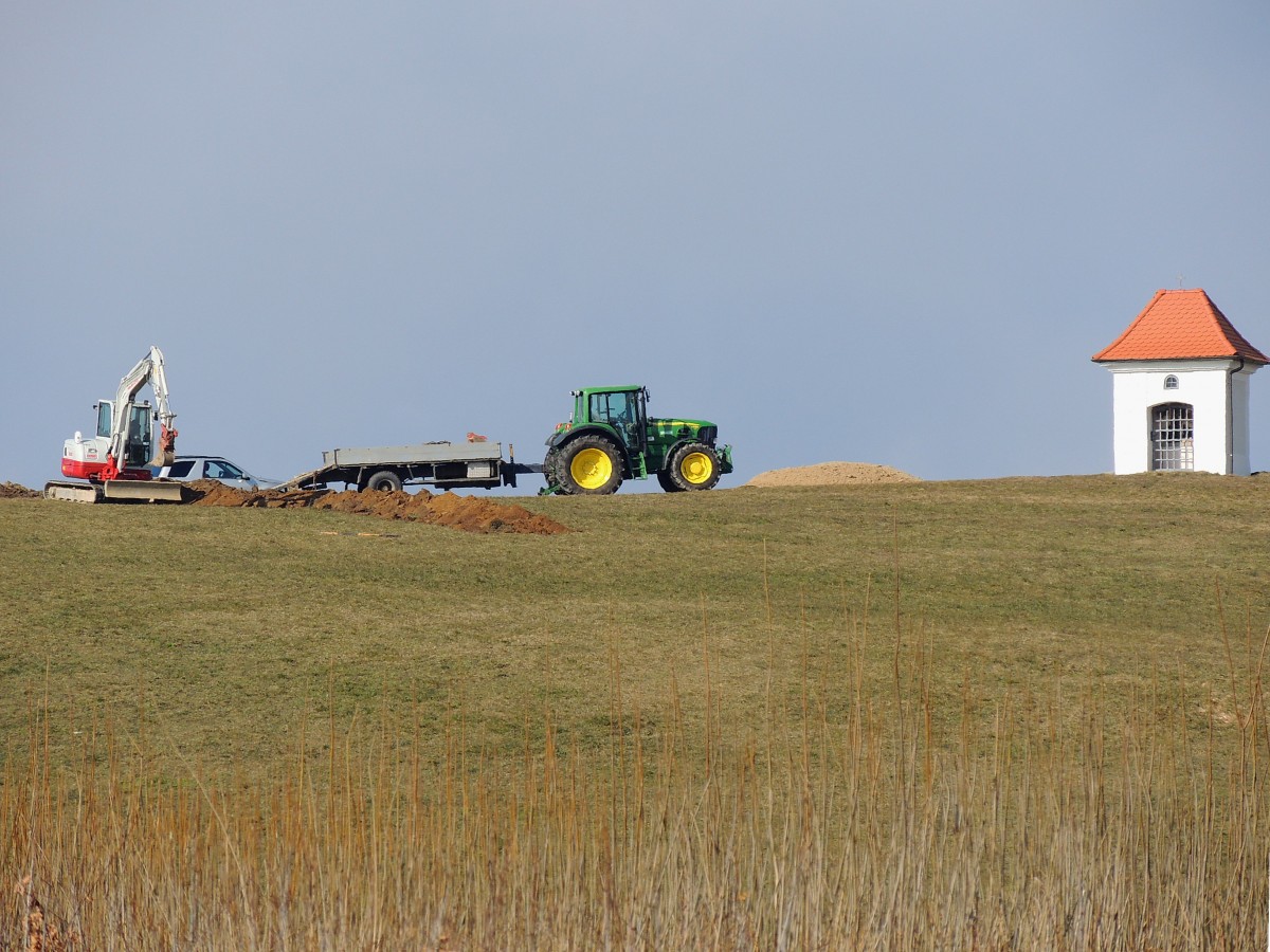 JohnDeere-6830, hat einen Kleinbagger herangeschafft; 150311