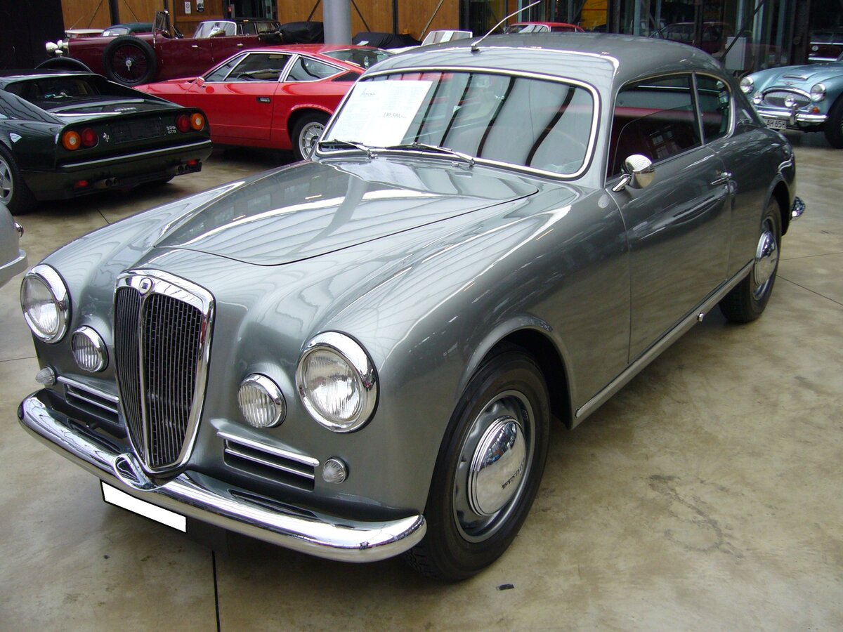 Lancia Aurelia B20 GT Coupe der Seria 4. Die erste Nachkriegsentwicklung der Marke Lancia wurde im Jahr 1950 unter der Modellbezeichnung Aurelia vorgestellt. Das von Vittorio Jano (*1891 +1965) entwickelte Modell zeichnete sich durch etliche technische Neuerungen aus. Die Aurelia-Baureihe war als als Berlina (Limousine), Coupe (Foto) und die offenen Modelle Spider und Convertible lieferbar. Vom Coupe wurden, von 1951 bis 1958 in insgesamt vier Baureihen, 3111 Fahrzeuge produziert. Auch die ästhetisch anmutende Karosserie des  Lancia-Hausschneiders  Pininfarina trug zum Erfolg dieses Modelles bei. Angetrieben wird das Auto von einem V6-Motor mit einem Hubraum von 2451 cm³ und einer Leistung von 118 PS. Classic Remise Düsseldorf im März 2022.