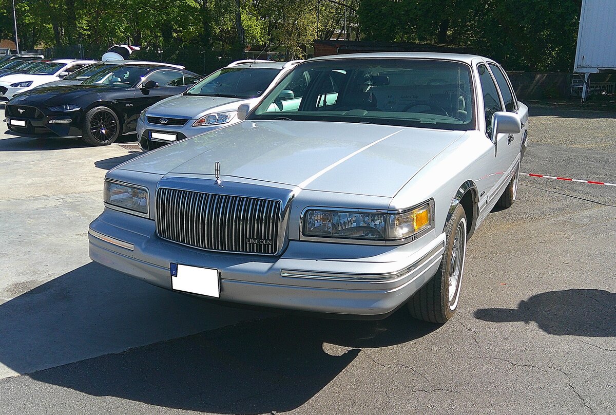 Lincoln Town Car Executive aus dem Jahr 1997 im Farbton silver frost. Im Jahr 1997 war das Modell  Town Car Executive  die Basisversion der legend�ren Full-Size-Luxuslimousine der Ford-Division Lincoln. Das Modelljahr 1997 markiert auch das letzte Jahr der zweiten Generation dieser Baureihe und das Ende der klassischen, kantigen, Karosserieform dieser Modellreihe. Die Executive Series positionierte sich unterhalb der Modellreihe  Signature  und des Toppmodells  Cartier . Sie bot dennoch reichlich amerikanischen Luxus, wie zum Beispiel das legend�r weiche Fahrgef�hl dank der hinteren Luftfederung. Der V8-Motor hat einen Hubraum von 4601 cm� und leistet rund 213 PS. Ford-Treffen am 26.04.2026 an Mo´s Bikertreff in Krefeld.