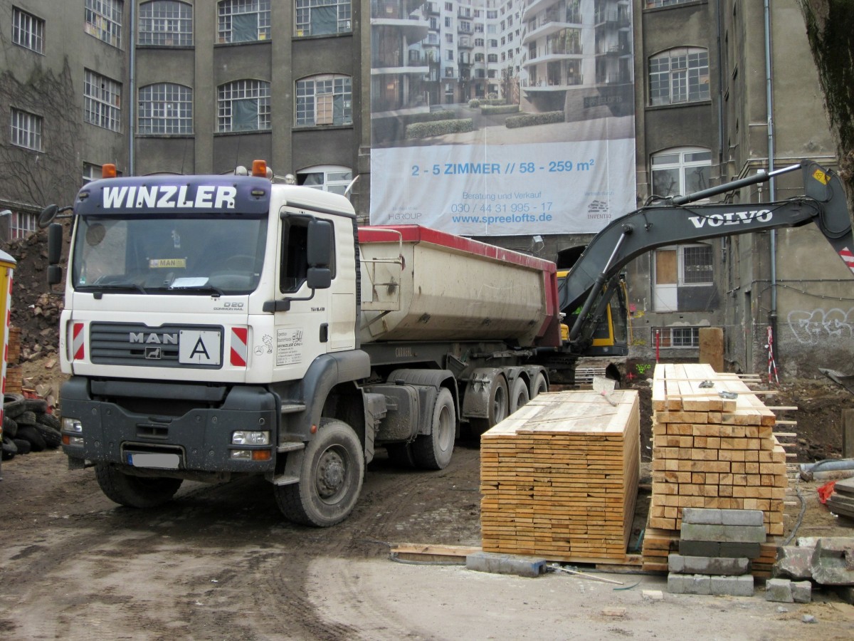 MAN TGA 18.430 wird am 15.01.2014 in Berlin-Charlottenburg von einem Volvo-Kettenbagger mit Bauaushub beladen.