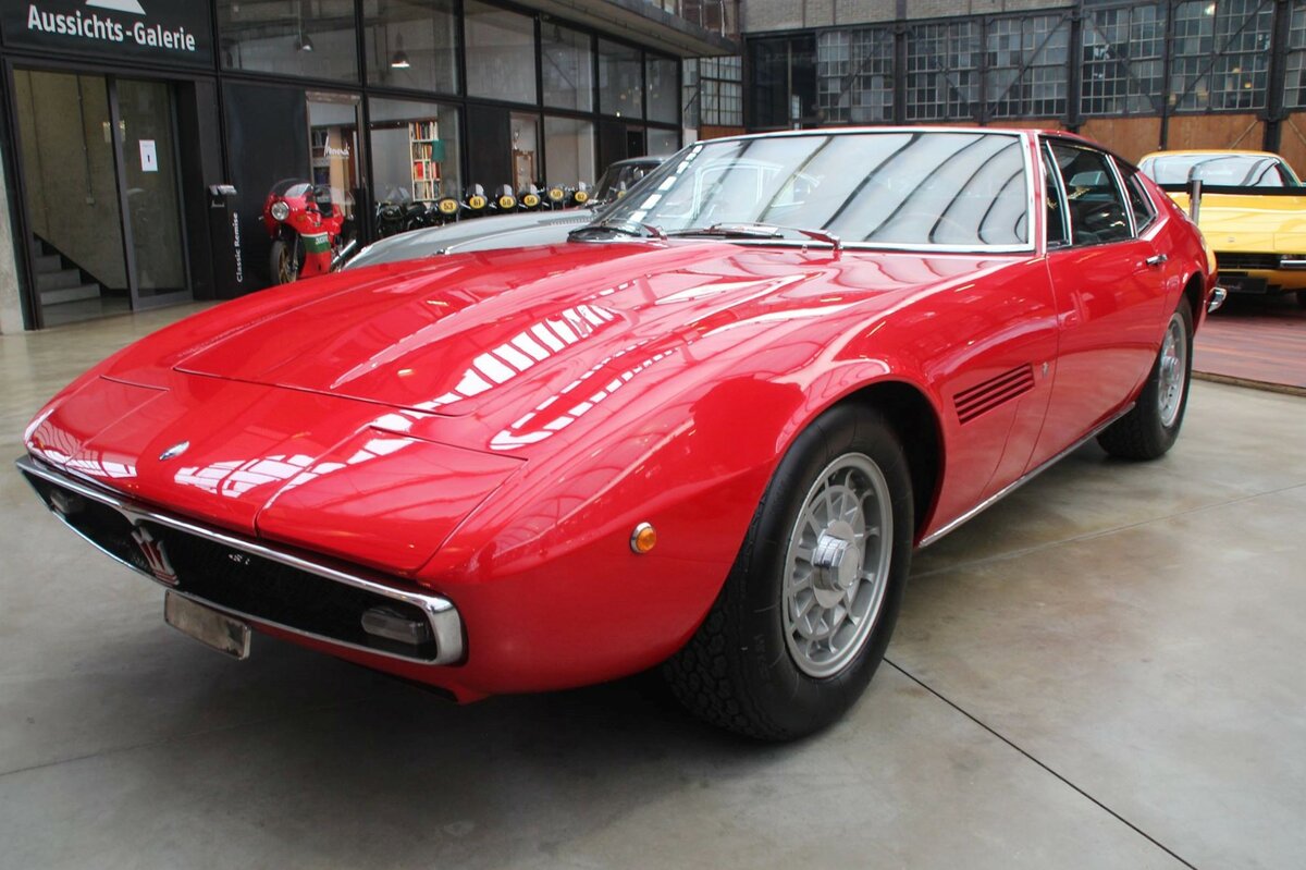 Maserati Ghibli 4.9 SS Coupe, gebaut von 1966 bis 1973. Der Ghibli ist nach einem Wüstenwind in der Sahara benannt. Das Sportcoupe konnte wahlweise mit zwei verschiedenen V8-Motoren bestellt werden: 4.7l Hubraum mit einer Leistung von 310 PS oder 4930 cm³ Hubraum mit einer Leistung von 335 PS. Die Höchstgeschwindigkeiten lagen bei 280 km/h bzw. 290 km/h. Es wurden 1.124 Coupe- und 125 Ghibli Cabriolets produziert. Classic Remise Düsseldorf am 13.07.2021.