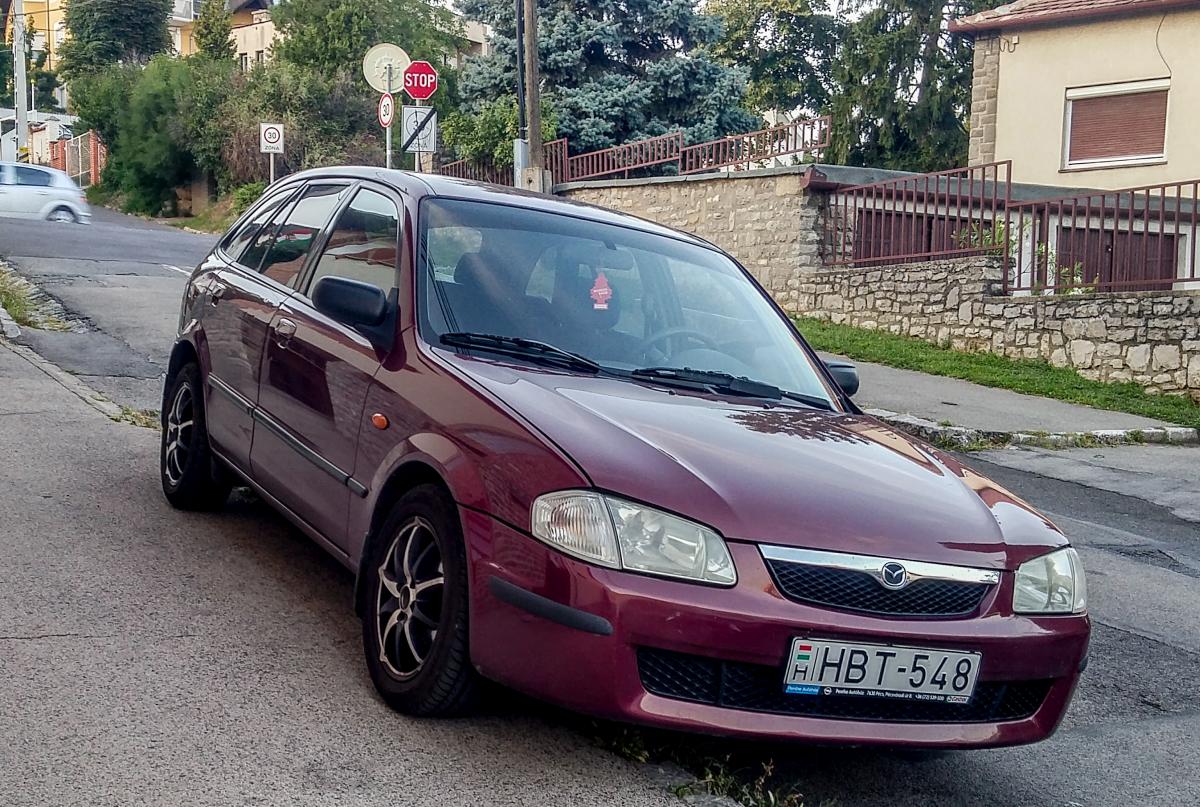 Mazda 323, fotografiert in Pécs (HU), August, 2019.
