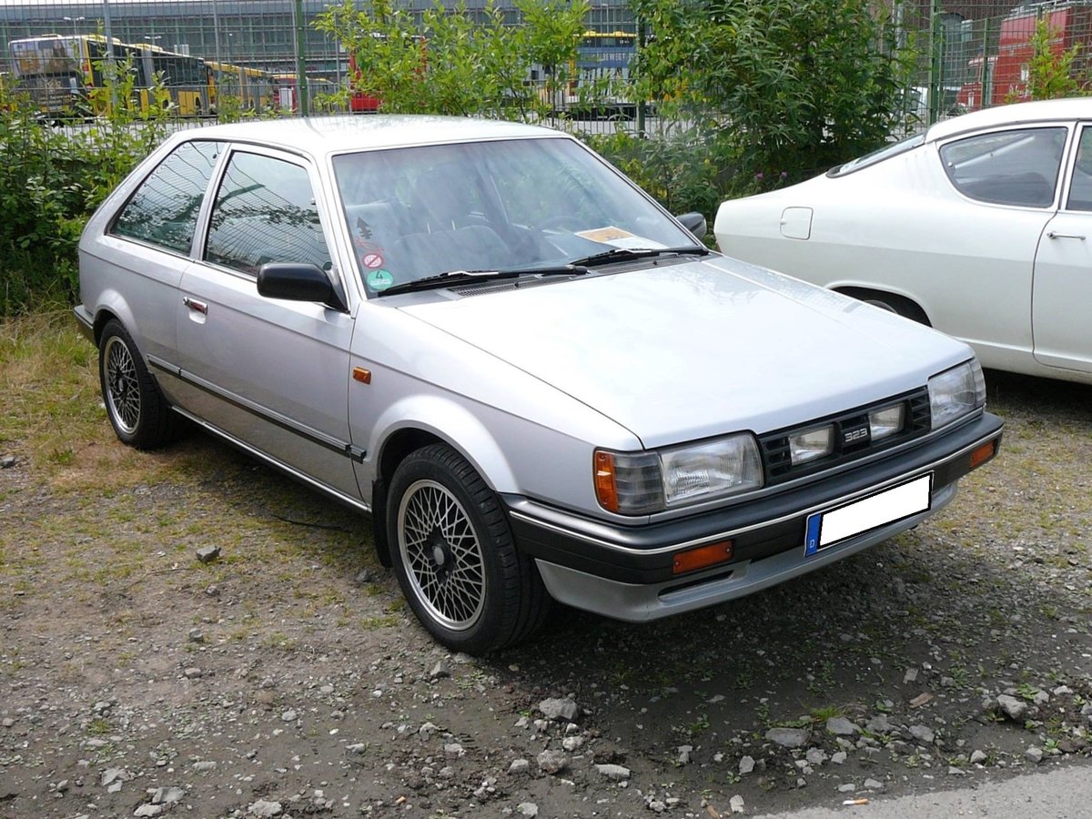 Mazda 323 der zweiten, in Europa verkauften Serie in der Karosserieversion zweitürige Schräghecklimousine. Weitere Varianten war die viertürige Schräghecklimousine, eine viertürige Stufenhecklimousine und ein fünftüriges Kombimodell. In dieser Form stand das Modell von 1980 bis 1985 bei den Händlern. Ein Fachzeitschrift nannte die Baureihe 323 einmal  Den Golf aus Hiroshima . Basismotorisierung war ein Vierzylinderreihenmotor mit einem Hubraum von 1071 cm³ und 55 PS. Der Basispreis betrug bei seiner Markteinführung DM 
10.990,00. Oldtimertreffen an der  Alten Dreherei  in Mülheim an der Ruhr im Juni 2015.