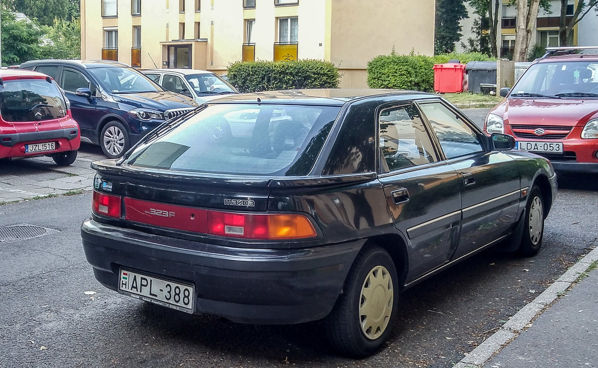 Mazda 323F (Rückansicht), aufgenommen in Pécs (HU), Juli, 2019.