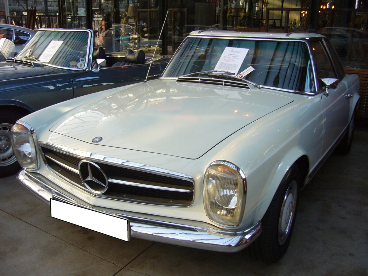 Mercedes Benz W113 280SL (E28) im Farbton papyrusweiß aus dem Jahr 1970. Produziert wurde der Sportwagen in den Jahren von 1968 bis 1971. Als Typ 230SL war der Zweisitzer bereits im Jahr 1963 erschienen. Der 280 SL war das stärkste Modell der sogenannten  Pagoden-Baureihe . In der Version 280SL verkaufte sich das Modell genau 23.885 mal. Der Sechszylinderreihenmotor leistet 170 PS aus einem Hubraum von 2778 cm³. Die Höchstgeschwindigkeit wurde damals mit 200 km/h angegeben. Classic Remise Düsseldorf am 30.11.2023.