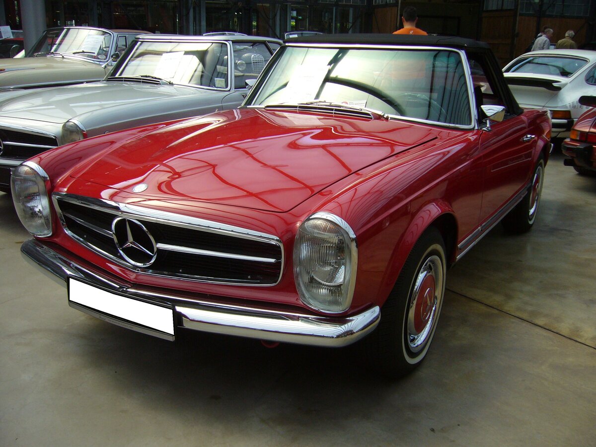 Mercedes Benz W113 280SL im Farbton signalrot aus dem Jahr 1971. Produziert wurde der Typ in den Jahren von 1968 bis 1971. Als Typ 230SL war das Modell bereits 1963 erschienen. Der 280 SL war das stärkste Modell der sogenannten  Pagoden-Baureihe . Als 280SL verkaufte sich das Modell genau 23.885 mal. Der Sechszylinderreihenmotor leistet 170 PS aus einem Hubraum von 2778 cm³. Die Höchstgeschwindigkeit wurde damals mit 200 km/h angegeben. Classic Remise Düsseldorf am 12.07.2022.