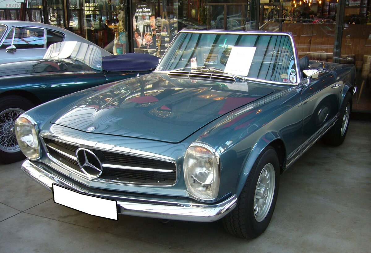 Mercedes Benz W113 (E28) 280SL aus dem Jahr 1971 im Farbton DB396 blaumetallic. Produziert wurde der Typ in den Jahren von 1968 bis 1971. Als Typ 230SL war der Zweisitzer bereits im Jahr 1963 erschienen. Der 280 SL war das stärkste Modell der sogenannten  Pagoden-Baureihe . Als 280SL verkaufte sich das Modell genau 23.885 mal. Der Sechszylinderreihenmotor leistet 170 PS aus einem Hubraum von 2778 cm³. Die Höchstgeschwindigkeit wurde damals mit 200 km/h angegeben. Der gezeigte 280SL ist mit einem Automaticgetriebe ausgerüstet. Classic Remise Düsseldorf am 30.11.2023.