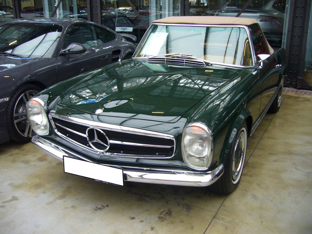 Mercedes Benz W113 (E28) 280SL in einem eleganten dunkelgrünen Farbton. Produziert wurde der Typ in den Jahren von 1968 bis 1971. Als Typ 230SL war der Zweisitzer bereits im Jahr 1963 erschienen. Der 280 SL war das stärkste Modell der sogenannten  Pagoden-Baureihe . Als 280SL verkaufte sich das Modell genau 23.885 mal. Der Sechszylinderreihenmotor leistet 170 PS aus einem Hubraum von 2778 cm³. Die Höchstgeschwindigkeit wurde damals mit 200 km/h angegeben. Der gezeigte 280SL ist mit einem Automaticgetriebe ausgestattet. Classic Remise Düsseldorf am 26.02.2024.