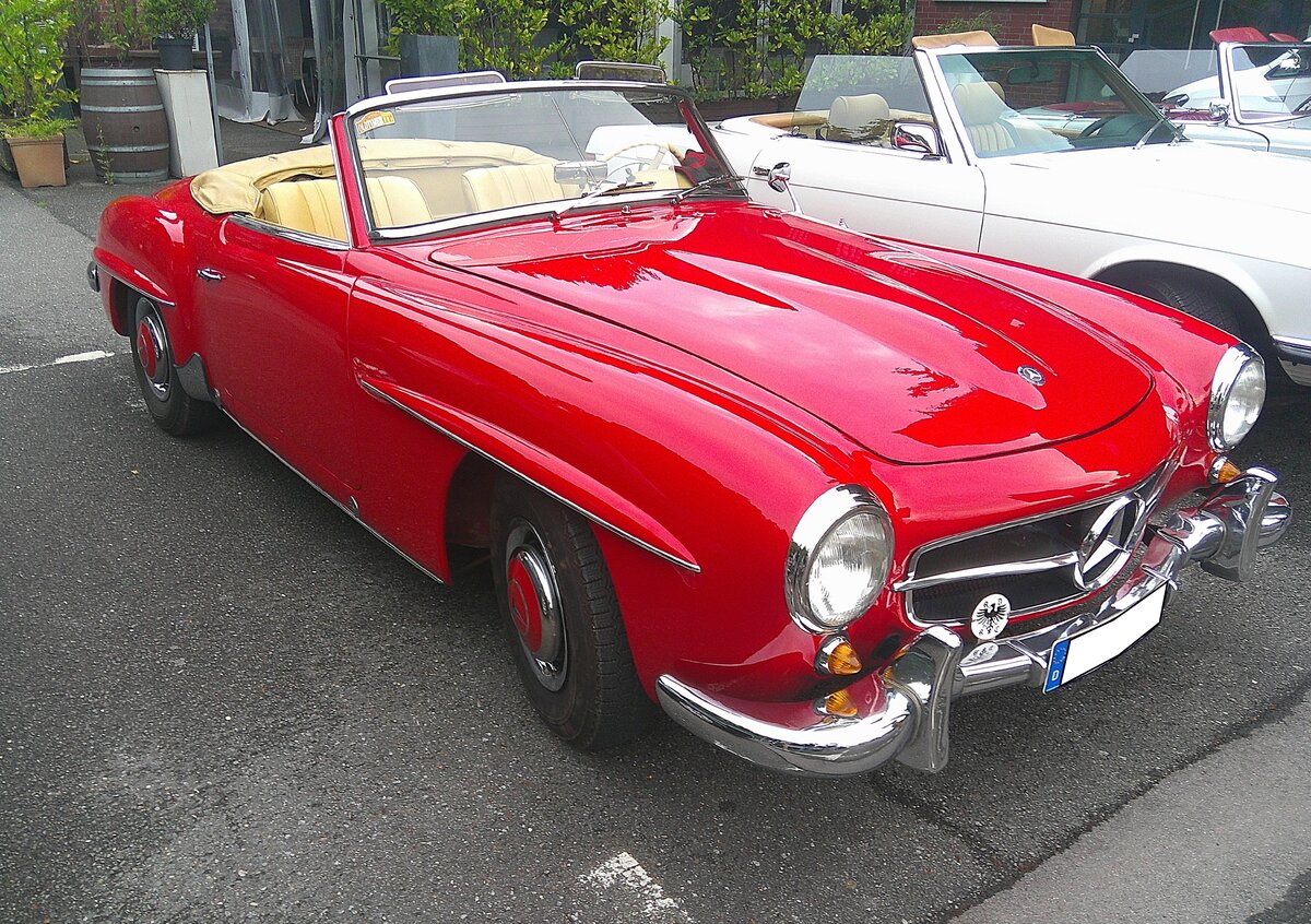 Mercedes Benz W121 BII, gebaut in den Jahren von 1955 bis 1963. Dieser Sportwagen ist besser bekannt unter der Typenbezeichnung 190SL. Genau 25.881 Fahrzeuge dieses Typs verlie�en die Werkshallen von Mercedes Benz. Dieser 190 SL aus dem Modelljahr 1956 ist im Farbton DB 534 feuerrot lackiert. Der Vierzylinderreihenmotor mit einem Hubraum von 1897 cm� leistet 105 PS. F�r einen solchen  Wirtschaftswunder-Sportwagen  war mindestens ein Kaufpreis von DM 16.500,00 f�llig. Ab September 1959 konnte der Kunde bzw. die Kundin ein festes Hardtop-Coupedach mit bestellen, um im Winter ein festes Dach �ber dem Kopf zu haben. 13. Saarner Oldtimer-Cup am 30.08.2026 in M�lheim an der Ruhr/Saarn.