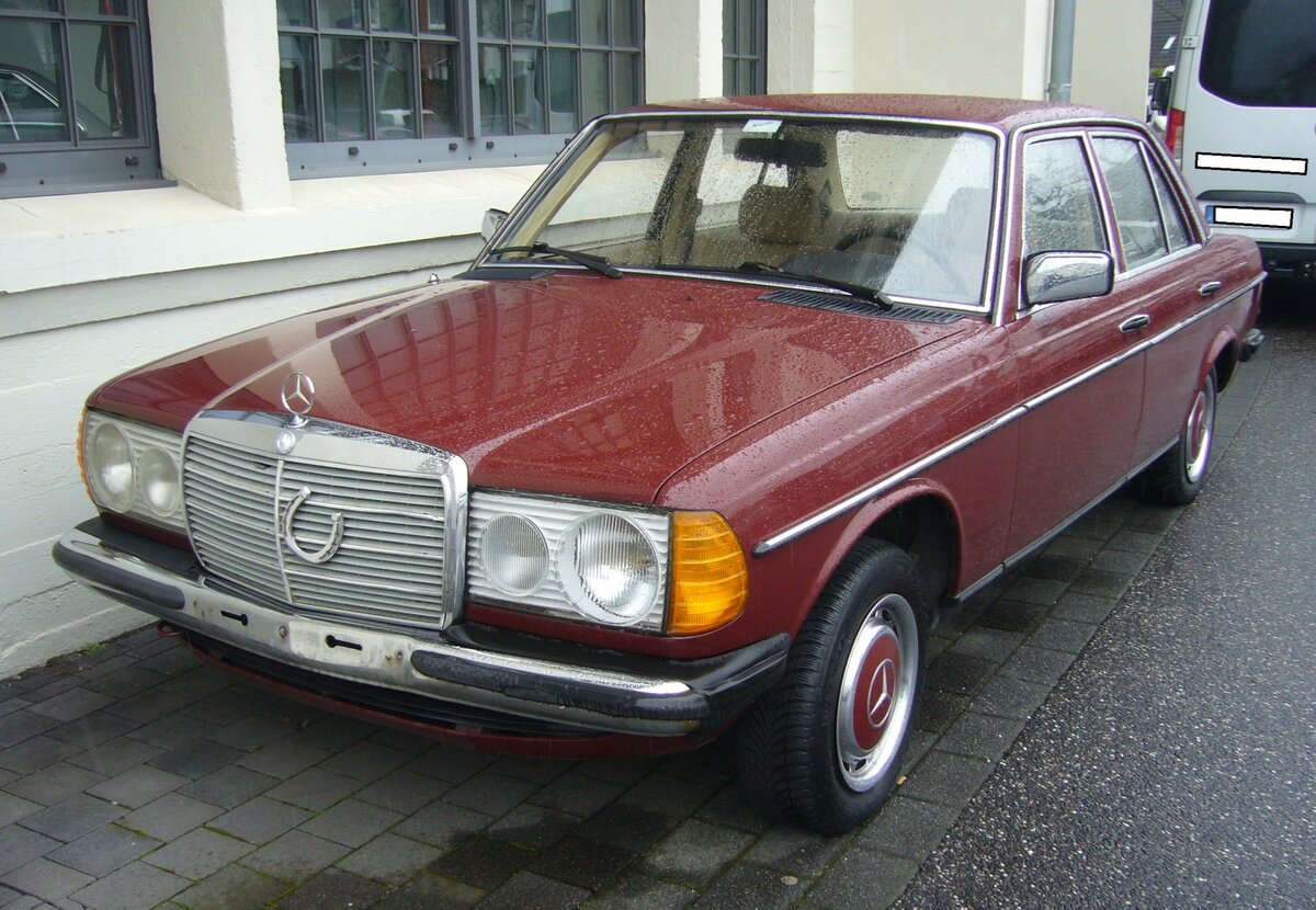 Mercedes Benz W123 200D. Im Januar 1976 wurde der  neue  Mercedes Benz W123 vorgestellt. Erst Mitte November 1985 endete die Produktion dieses  Dauerbrenners . Im Laufe der Jahre wurde die Modellpalette um ein formschönes Coupe und das T-Modell genannte Kombifahrzeug erweitert. Der 200D het einen  Vierzylinderdieselmotor mit einem Hubraum von 1988 cm³. Anfänglich leistete dieser Motor 55 PS. Ab Februar 1979 erhöhte sich die Leistung auf 60 PS. Mit einer Höchstgeschwindigkeit von nur 130 km/h hatte der 200D schnell seinen Spitznamen  Wanderdüne  weg. Bei seiner Markteinführung kostete ein solches Auto mindestens DM 18.900,00. Aber die Liste für sinnvolles Zubehör war lang. So kostete eine zusätzliche Servolenkung im Jahr 1976 DM 700,00, ein Automaticgetriebe DM 1.700,00, ein elektrisches Schiebedach DM 1.100,00 und das günstigste Radio DM 800,00 zusätzlich. Besucherparkplatz der Düsseldorfer Classic Remise am 26.02.2024.