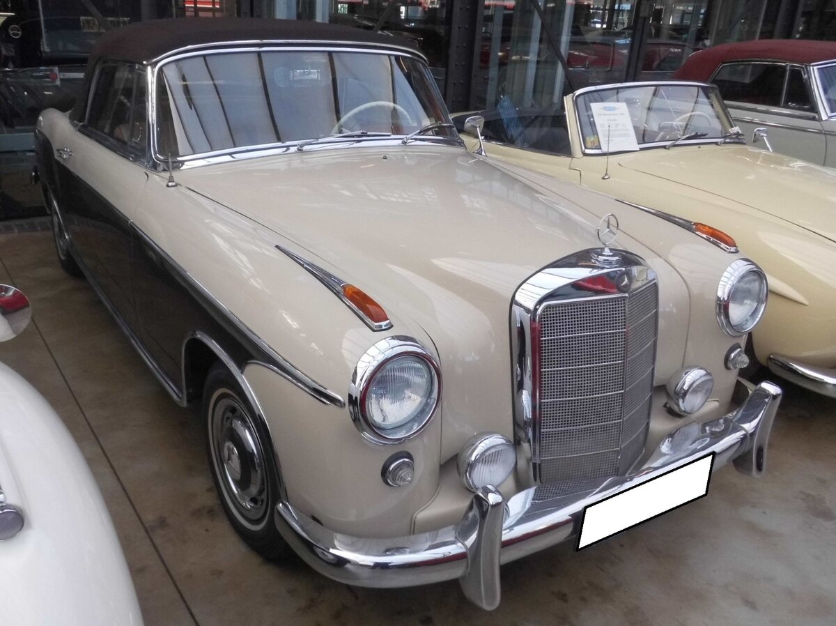 Mercedes Benz W180/2 220S Cabriolet. Dieses Modell war von 1956 bis 1959 im Verkaufsprogramm von Mercedes Benz. Das gezeigte Cabriolet in der Bicolor-Lackierung tabakbraun/beige wurde erstmalig im Jahr 1958 zugelassen. Ein solches Cabriolet kostete, bei einem Kaufpreis von DM 21500,00, fast doppelt so viel, wie die Limousine, die mit DM 12.500,00 in der Preisliste von Mercedes Benz stand. Der Mehrpreis für das Cabriolet hätte für den Erwerb von zwei VW Käfern gereicht. Der von einem Solex-Registervergaser  befeuerte  Sechszylinderreihenmotor hat einen Hubraum von 2195 cm³ und leistet 100 PS. Classic Remise Düsseldorf am 02.03.2026.