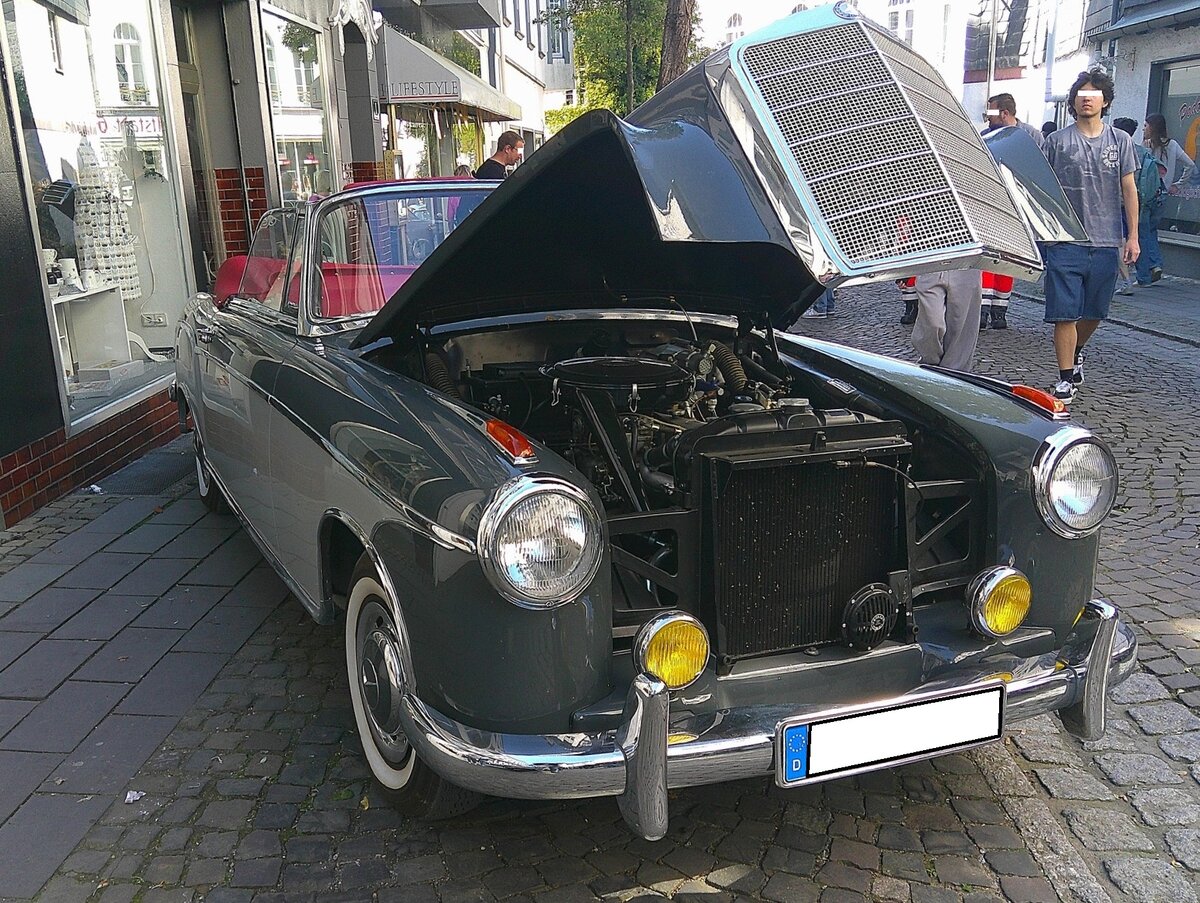 Mercedes Benz W180/2 220S Cabriolet. Dieses Modell war von 1956 bis 1959 im Verkaufsprogramm von Mercedes Benz. Das gezeigte Cabriolet in der Bicolor-Lackierung tabakbraun/beige wurde erstmalig im Jahr 1958 zugelassen. Ein solches Cabriolet kostete, bei einem Kaufpreis von DM 21500,00, fast doppelt so viel, wie die Limousine, die mit DM 12.500,00 in der Preisliste von Mercedes Benz stand. Der Mehrpreis f�r das Cabriolet h�tte f�r den Erwerb von zwei VW K�fern gereicht. Der von einem Solex-Registervergaser  befeuerte  Sechszylinderreihenmotor hat einen Hubraum von 2195 cm� und leistet 100 PS. Oldtimer Fr�hling des AMC Kettwig am 01.05.2026 in Essen Kettwig.
