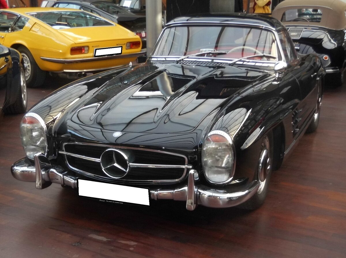 Mercedes Benz W198 I 300SL, gebaut in den Jahren von 1954 bis 1957. Über den, auch  Gullwing  genannten Wagen, wurde bereits soviel geschrieben, das ich mich hier mit den technischen Daten begnüge. Der Sechszylinderreihenmotor hat einen Hubraum von 2996 cm³ und leistet 215 PS, die dem Wagen, je nach bestellter Hinterradübersetzung, zu einer Höchstgeschwindigkeit von 220 km/h bis 250 km/h verhelfen. Der gezeigte 300SL wurde ursprünglich in die USA ausgeliefert. Seit 1995 war er dann wieder auf deutschen Straßen unterwegs. Classic Remise Düsseldorf am 15.01.2026.