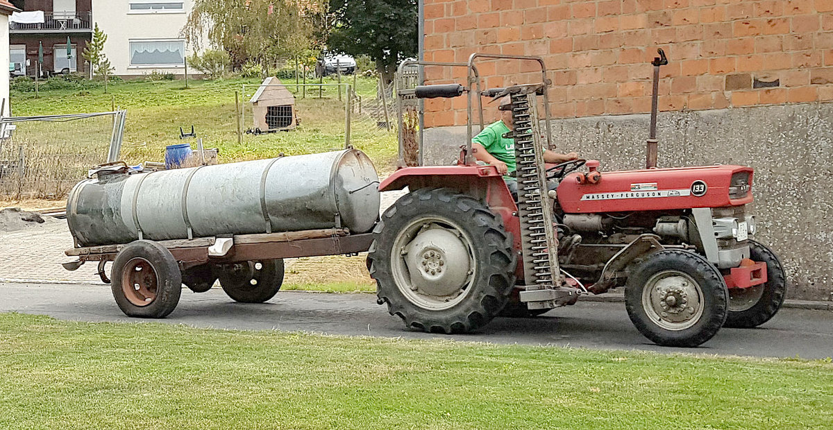 =MF 133 transportiert Frischwasser für die Weidetiere im August 2019