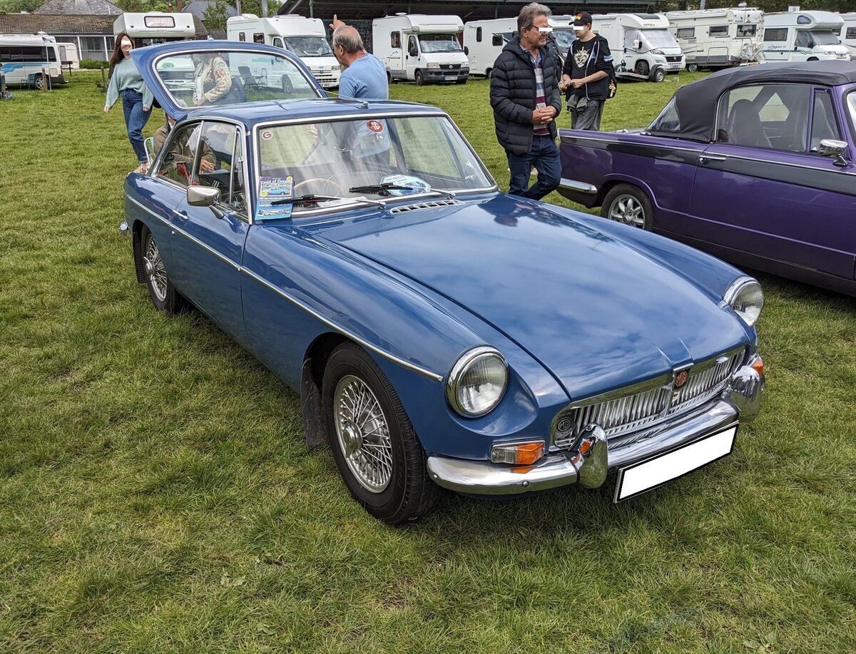 MG B GT 1800. Der MG B Roadster wurde bereits 1962 eingeführt. Im Oktober 1965 kam der als 2+2 Sitzer ausgelegte MG B GT zusätzlich auf den Markt. Er war, genau wie der Roadster, bis 1980 im Verkaufsprogramm der Marke aus Coventry. Während sich das Roadster Modell während der gesamten Produktionszeit fast 400.000 mal verkaufte, wurde vom GT Modell genau 125.282 Einheiten abgesetzt. Der Vierzylinderreihenmotor hat einen Hubraum von 1798 und leistet 92 PS. Die Höchstgeschwindigkeit lag bei 168 km/h. Der gezeigte Wagen wurde im Jahr 1968 produziert und dürfte im Farbton mineral blue lackiert sein. Steam and vintage show am 27.05.2024 in Abergavenny/South Wales.
