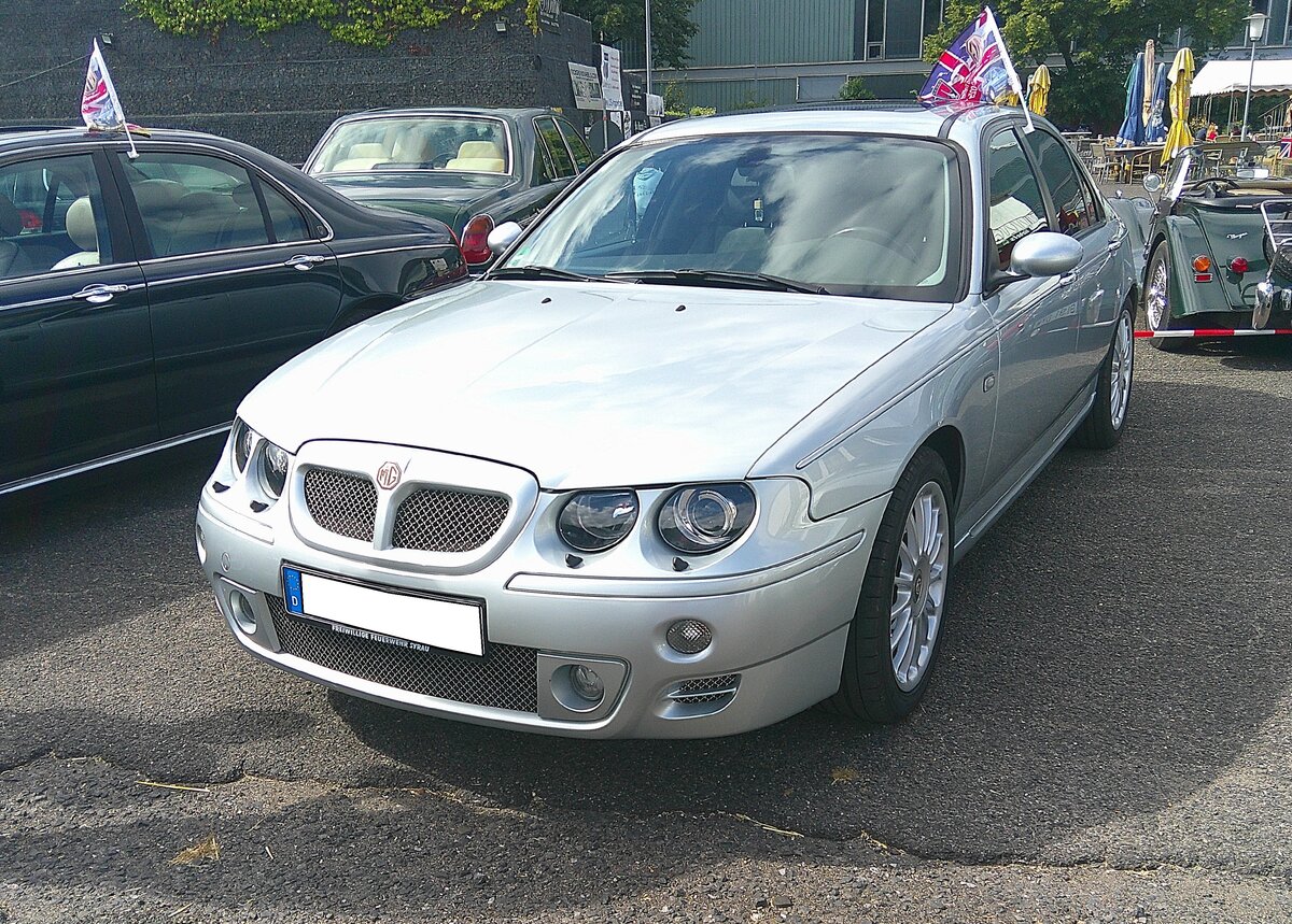 MG ZT190 im Farbton starlight silver. Auf der Basis des Rover 75 brachte die MG-Rover Rover Group im Jahr 2001 auch die Baureihe ZT190 (Limousine, wie auf dem Foto)) und ZT-T190 (Kombi) auf den Markt. Im Vergleich zum komfortabel ausgelegten Rover 75, waren die ZT190 Modelle auf Sportlichkeit ausgelegt. Der ZT190 verf�gt ab Werk �ber ein sp�rbar strafferes Fahrwerk, direktere Lenkung und eine gr��ere Bremsanlage. Der V6-Motor hat einen Hubraum von 2497 cm� und leistet, wie aus der Typenbezeichnung schon abzulesen ist, 190 PS. Die H�chstgeschwindigkeit wurde damals mit 227 km/h angegeben. 10. BCMM ( B ritish C ar M otorcycle M eeting) am 19.07.2026 an Mo´s Bikertreff in Krefeld.