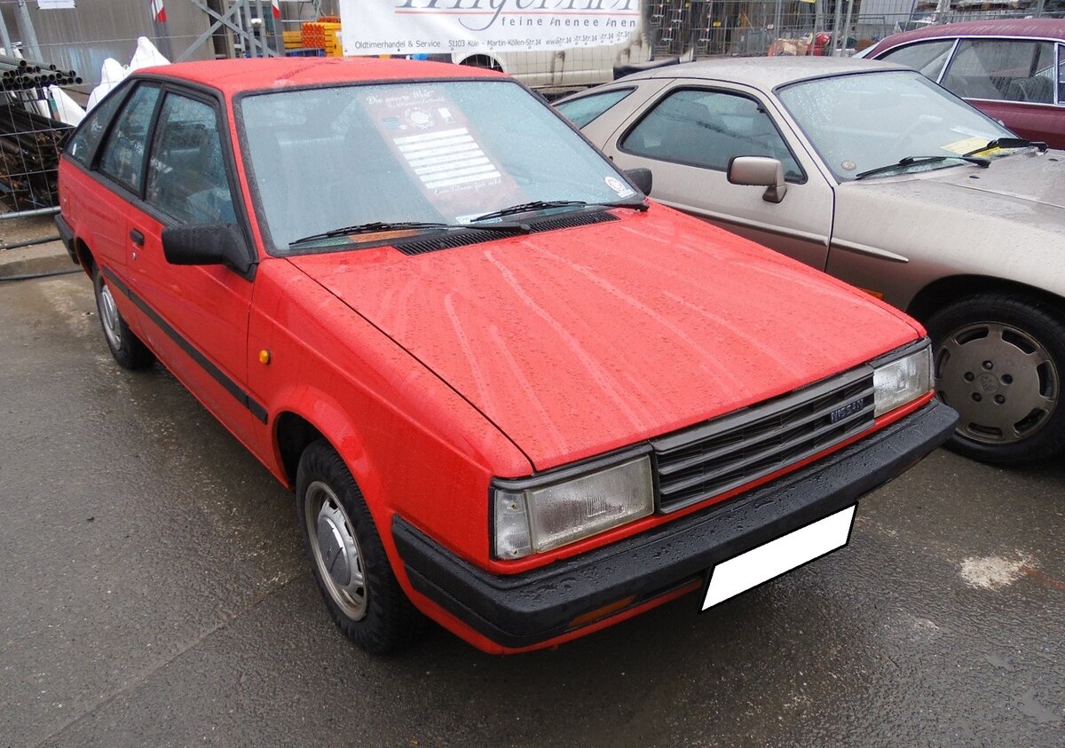 Nissan Sunny Coupe der Baureihe B11, wie er von 1982 bis 1985 verkauft wurde. Gemäß Vorstandsbeschluss sollte bis zum Herbst 1983 der Markenname Datsun weltweit gegen Nissan ausgetauscht worden sein. In Europa war der erste  Täufling  mit dem Namen Nissan das neue Kompaktmodell Sunny B11. Der B11 war in Deutschland als viertürige Stufenhecklimousine, als fünftüriges Kombimodell namens  Traveller  und eben als dreitüriges Coupe (Foto) lieferbar. Ein solches Coupe war bei seiner Markteinführung ab DM 13.795,00 zu haben. Der Vierzylinderreihenmotor hat einen Hubraum von 1477 cm³ und leistet 75 PS. Die Höchstgeschwindigkeit gab Nissan mit 160 km/h, bei einem Verbrauch von 7,6 Litern auf 100 Kilometer an. Messeparkplatz der Essener Techno Classica vor einigen Jahren.