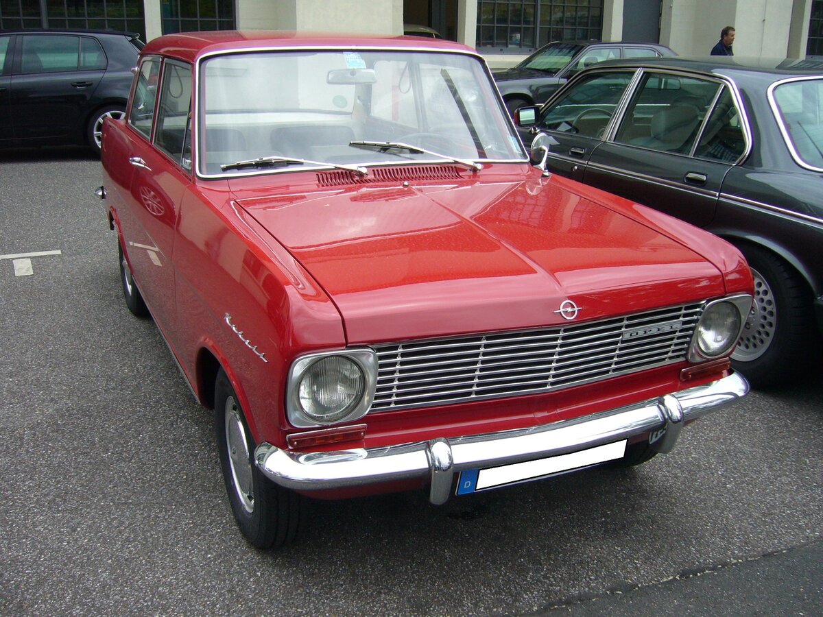 Opel Kadett A Limousine in L-Ausstattung, gebaut von 1963 bis 1965. Der Kadett A, für den eigens das mittlerweile wieder geschlossene Opel-Werk in Bochum errichtet wurde, kam ab Oktober 1962 zu den Opel-Händlern. Das luxuriösere Modell L, erkennbar an den im Zierrahmen steckenden Frontscheinwerfern und einem anderen Kühlergrill, stand ab März 1963 bei den Händlern. Die Kunden konnten, den mit einem Vierzylinderreihenmotor und einem Hubraum von 993 cm³ motorisierten Kadett A wahlweise mit einem 40 PS oder einem 48 PS Motor ordern. Besucherparkplatz der Düsseldorfer Classic Remise am 07.06.2021.