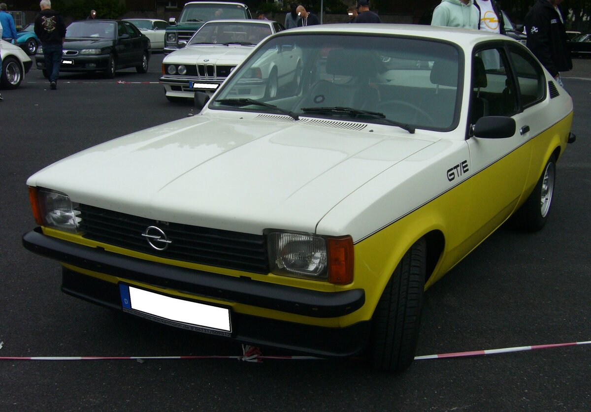 Opel Kadett C GT/E aus dem Jahr 1978. Der Opel Kadett C wurde im August 1973 vorgestellt und bis Juli 1979 produziert. Der Wagen war als zwei- und viertürige Limousine, Coupe und als dreitüriges Kombimodell CarAvan lieferbar. Der GT/E war das sportlichste Modell dieser Baureihe. In der abgelichteten Farbkombination polarweiß/brilliantgelb war er nur von September 1977 bis Produktionsende lieferbar. Ein solcher GT/E stand bei seiner Markteinführung mit einem Kaufpreis von DM 16.850,00 in der Preisliste. Der Vierzylinderreihenmotor hat einen Hubraum von 1979 cm³ und leitet 115 PS. Die Höchstgeschwindigkeit gab das Werk mit 190 km/h an. Oldtimer- und Youngtimertreffen an Mo´s Bikertreff in Krefeld am 08.10.2023.