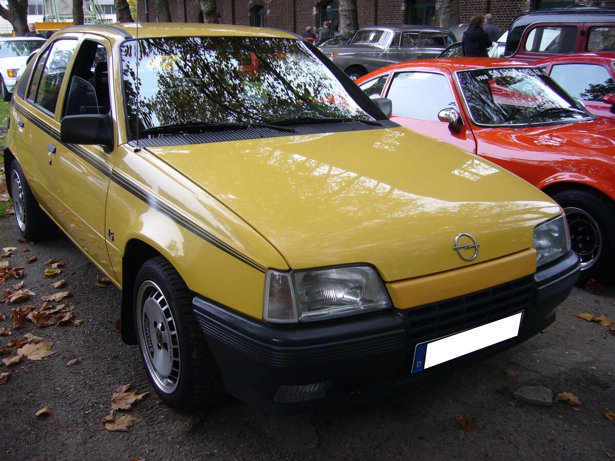 Opel Kadett E LS 1.3i aus dem Jahr 1986. Der Kadett E war das letzte Modell der Opel-Kadett-Baureihe und wurde im August 1984 vorgestellt. Im Januar 1986 brachte Opel das Modell mit einem 1.3 Liter Katalysator-Motor auf den Markt. Mit diesem Motor ist auch der hier gezeigte Kadett E ausgerüstet. Dieser Vierzylinderreihenmotor hat einen Hubraum von 1297 cm³ und leistet 60 PS. Die Höchstgeschwindigkeit wurde werksseitig mit 160 km/h angegeben. Für eine solche, fünftürige, Kadett E Limousine im Farbton jamaicagelb musste man im Jahr 1986 mindestens DM 18.650,00 anlegen. Oldtimertreffen am Theater an der Niebu(h)rg in Oberhausen am 23.10.2022.