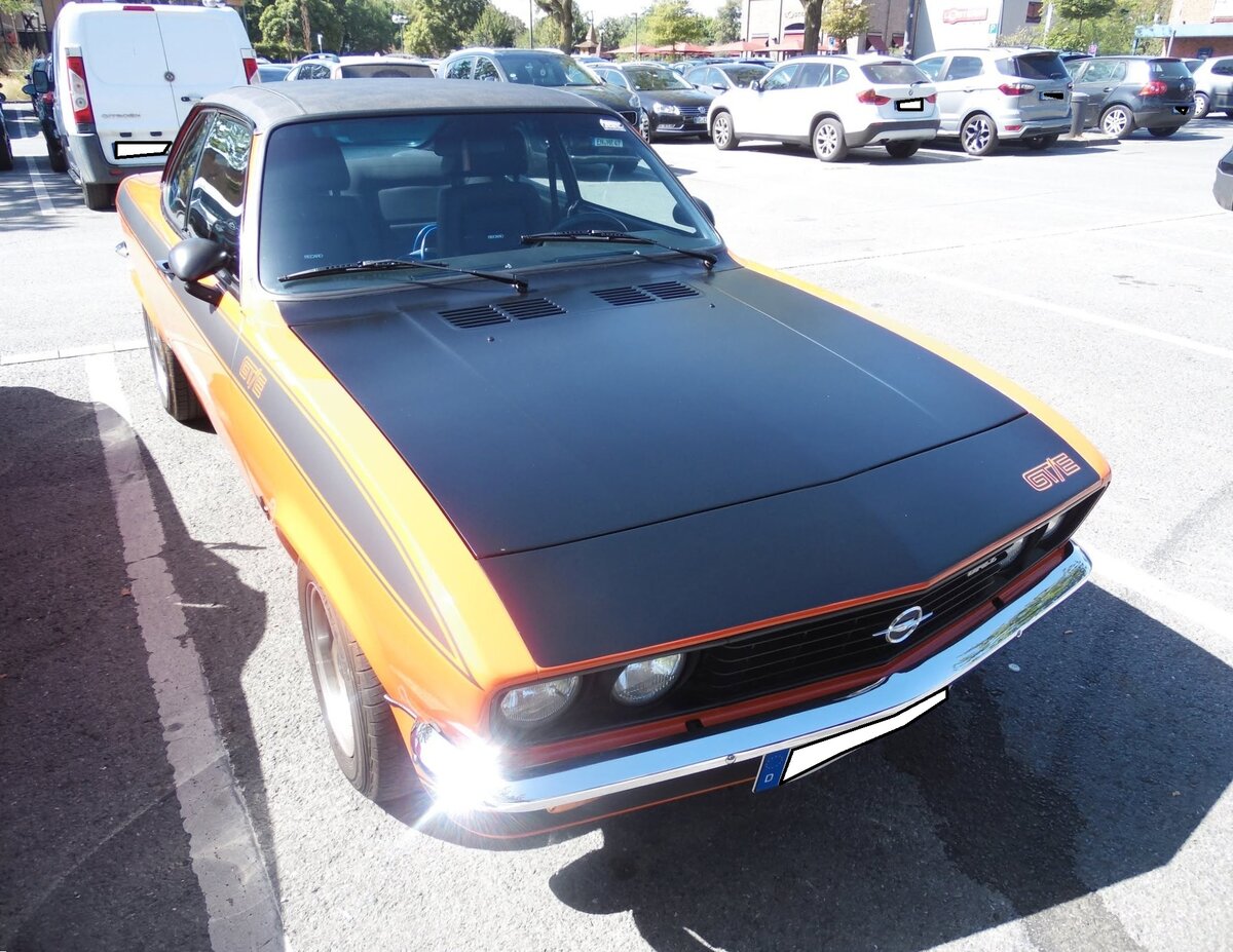 Opel Manta A GT/E im Farbton signalrot, produziert in den Jahren 1974 und 1975 Das Manta A Coupe wurde bereits 1970 auf der Basis des Ascona A auf den Markt gebracht. 1974 brachten die R�sselsheimer als Spitzenmodell dieser Baureihe, den besonders sportlichen GT/E auf den Markt. Bei seiner Markteinf�hrung kostete ein solcher GT/E in der Basisversion DM 12.530,00. Daf�r bekam man ein sportliches, viersitziges Coupe mit einem Vierzylinderreihenmotor, der serienm��ig aus einem Hubraum von 1897 cm� 105 PS leistet. Der gezeigte GT/E wurde 1975 erstmalig zum Stra�enverkehr zugelassen. Oldtimertreffen am  Cafe del Sol  in Gelsenkirchen am 09.08.2026.