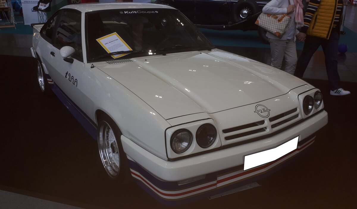 Opel Manta B i200. Die sogenannten i-Modelle warenn von Opel-Tuner Irmscher veredelte Modelle, die zum Teil direkt über Opel-Händler bestellt werden konnten. Neben dem i200 gab es auch noch den i240 mit 2,4-Liter-Motor, den nur 27 Mal gebauten i300 mit dem Sechszylinderreihenmotor aus dem Monza/Senator und den legendären i400, von dem 245 Stück gebaut wurden. Der i200, wurde immer mit dem charakteristischen Dekor der Zigarettenmarke  Rothmans , in den Farben Blau, Rot und Gold ausgeliefert. Zu den genauen Stückzahlen gibt es unterschiedliche Angaben, während einzelne Quellen von mehr als 5000 Autos sprechen, nennen andere Quellen nur 3074 gebaute Fahrzeuge. Besondere Eye-catcher des i200 sind der dreiteilige Heckspoiler, das bereits genannte Rothmans-Dekor und die Recaro-Sportsitze mit den Sitzbezügen auf denen der  Opel Blitz  eingewebt ist. Während der  normale  Manta B mit seinem Vierzylinderreihenmotor mit einem Hubraum von 1979 cm³ 110 PS leistete, konnte Irmscher dem Motor mittels einer scharfer Nockenwelle und entsprechendem Zündverteiler 125 PS entlocken. Retro Classics in Essen am 09.04.2026.