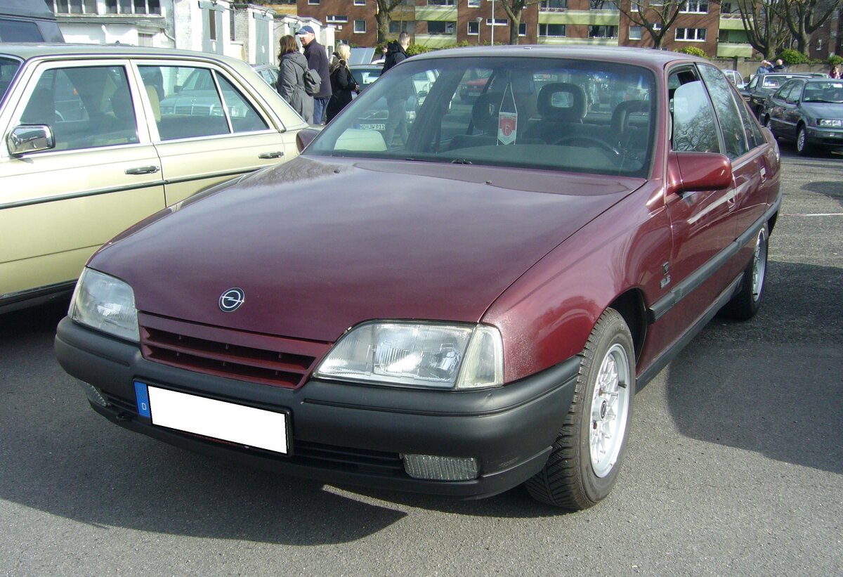 Opel Omega A Limousine 2.4i in der Ausstattungsvariante Diamant GLS. Die Omega A Limousine stand ab August 1986 bei den Vertragshändlern. In den Jahren von 1988 bis 1990 wurde das gezeigte Sondermodell Diamant GLS verkauft. Sie umfasste neben einer Mineraleffekt-Lackierung in den Farben: Schwarz, Bordeauxrot (Foto) und Kobaltblau, auch einen in Wagenfarbe lackierten Kühlergrill und Außenspiegel, getönte Scheiben, Nebelscheinwerfer, das Stereo-Cassettenradio SC 202, ein Lederlenkrad, einen lederbezogenen Schaltknauf, Schalthebelsack und Handbremshebel. Zusätzlich noch Alu-Felgen der Dimension 7J x 15 in besonderem Design mit Reifen der Größe 195/65 R 15 H. Der in diesem Wagen verbaute Vierzylinderreihenmotor hat einen Hubraum von 2410 cm³ und leistet 125 PS. Oldtimertreffen an Mo´s Bikertreff in Krefeld am 10.03.2024.
