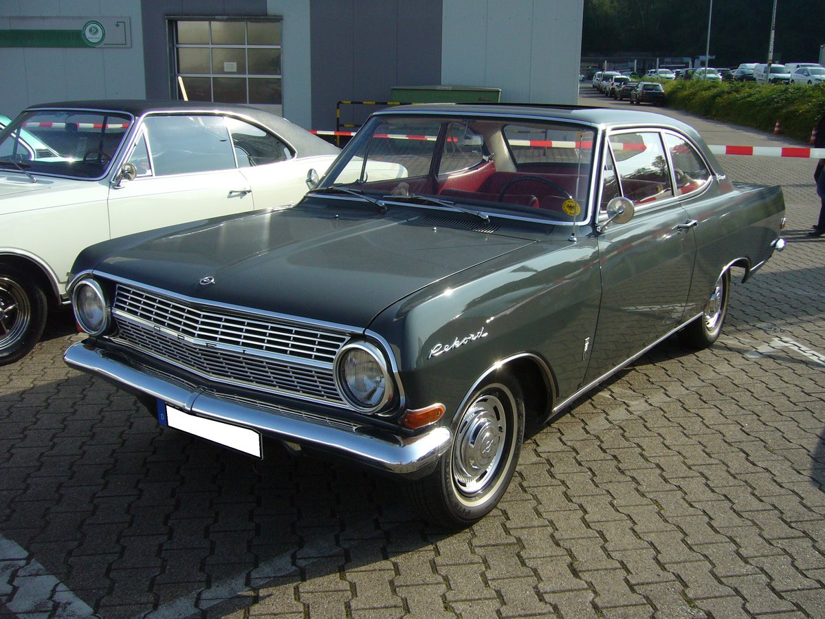 Opel Rekord A L Coupe. 1963 - 1965. Der Rekord A kam im Stil des Chevrolet II daher. Es gab folgende Karosserievarianten: Limousine zweitürig, Limousine viertürig, einen dreitürigen CarAvan, einen dreitürigen Kastenwagen und das Coupe. Der abgelichtete Wagen ist ein Coupe 1700L im Farbton schiefergrau. Der 4-Zylinderreihenmotor leistet 60 PS aus 1680 cm³ Hubraum. Ein solches Coupe hatte bei seiner Markteinführung einen Basispreis von DM 8015,00. Oldtimertreffen Opel van Eupen in Essen am 24.09.2016.
